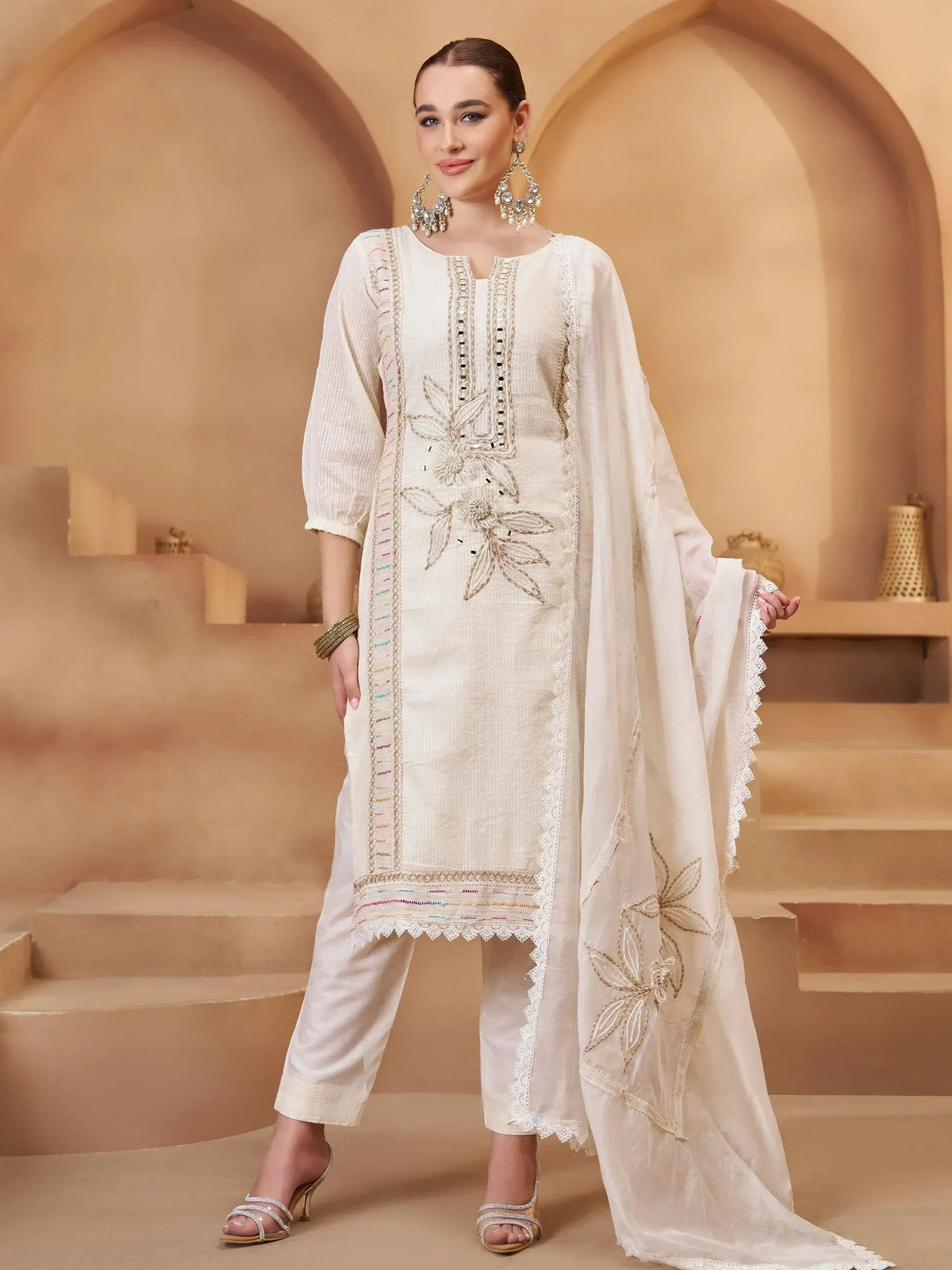 Elegant white embroidered salwar kameez with floral detailing and lace trim, perfect for ethnic occasions.