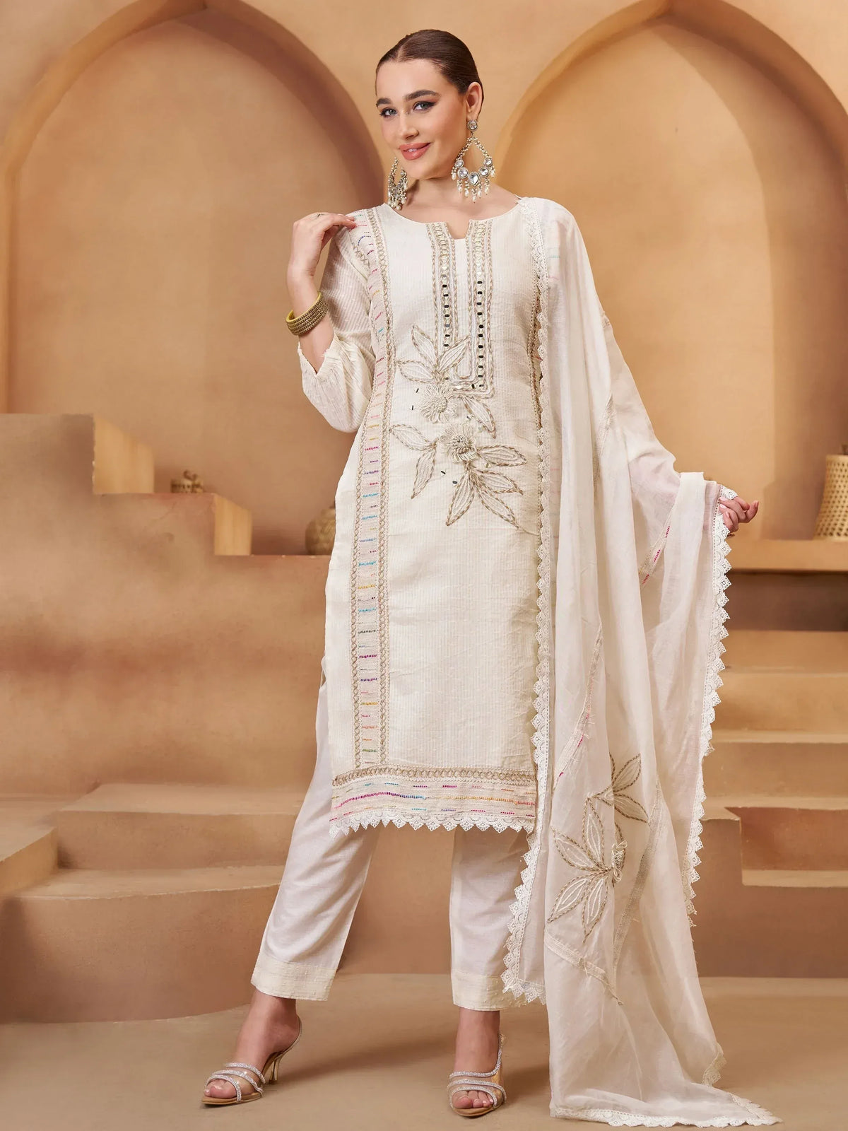 Elegant white embroidered salwar kameez with floral detailing and lace trim, perfect for Indian ethnic wear.
