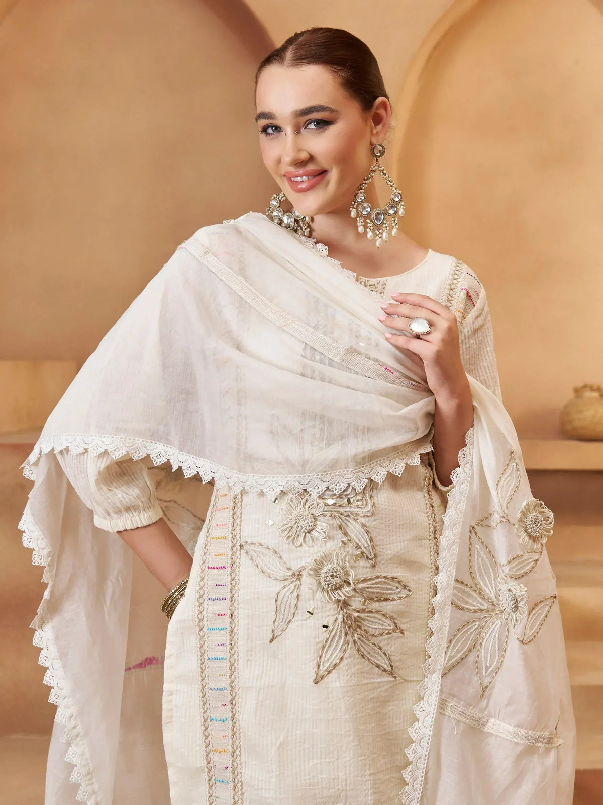 Elegant white embroidered salwar kameez with floral detailing and lace trim, perfect for ethnic occasions.