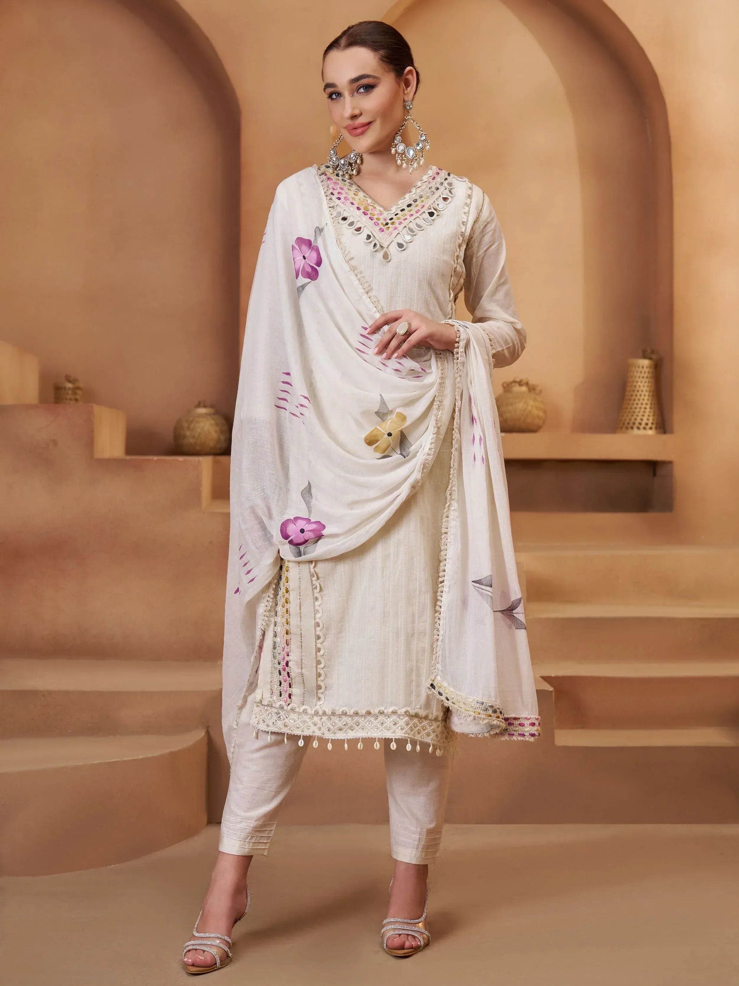 Cream salwar kameez with floral dupatta, mirror work, and ethnic embroidery for women