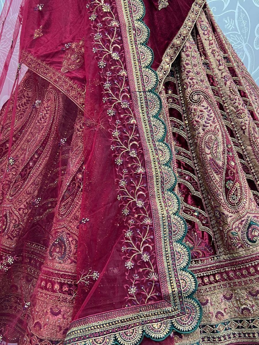 Luxury maroon lehenga choli with intricate gold embroidery and paisley motifs, perfect for Indian weddings.