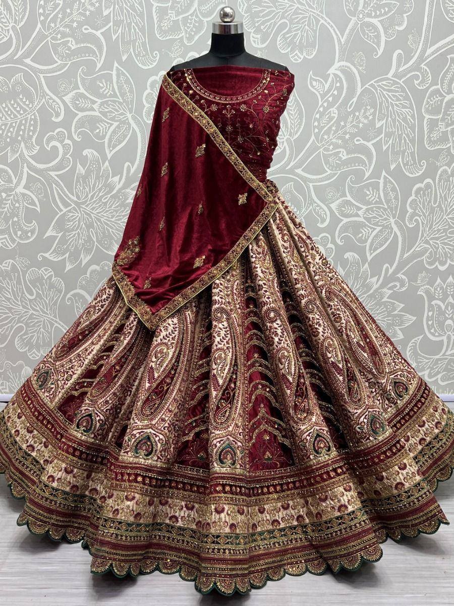 Maroon velvet lehenga choli with gold paisley embroidery, perfect for Indian weddings and festive occasions.