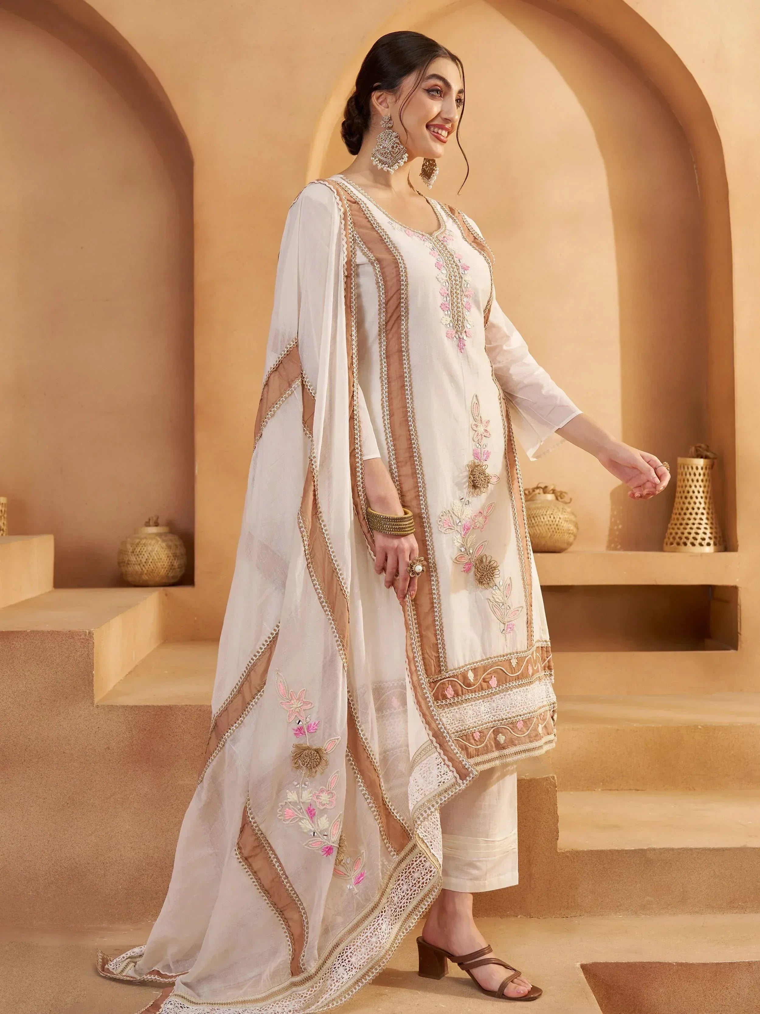 Elegant white embroidered kurta with floral detailing, paired with matching pants and dupatta, perfect for Indian ethnic occasions.