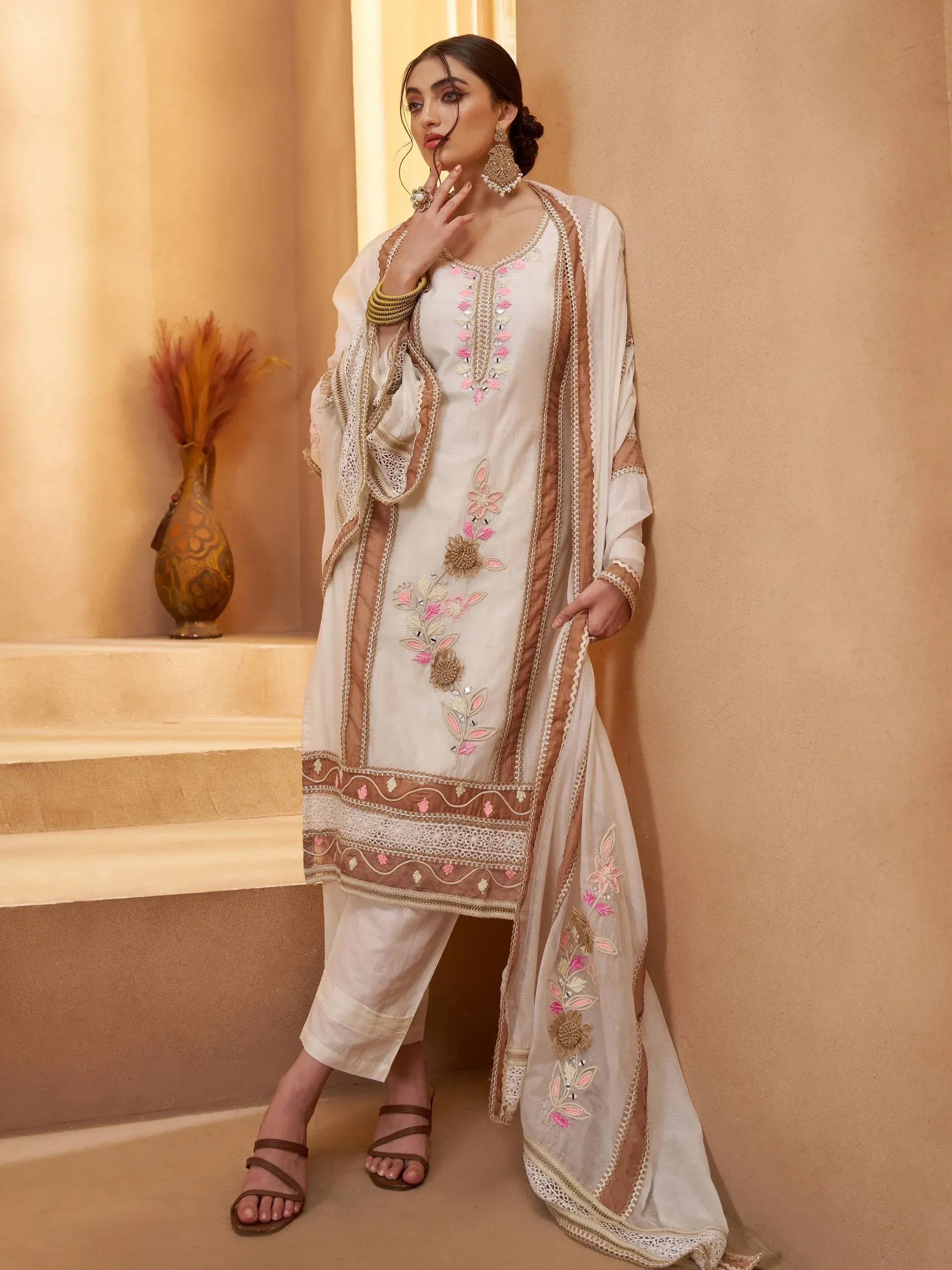 Elegant white salwar kameez with pink floral embroidery and gold detailing, perfect for ethnic occasions.
