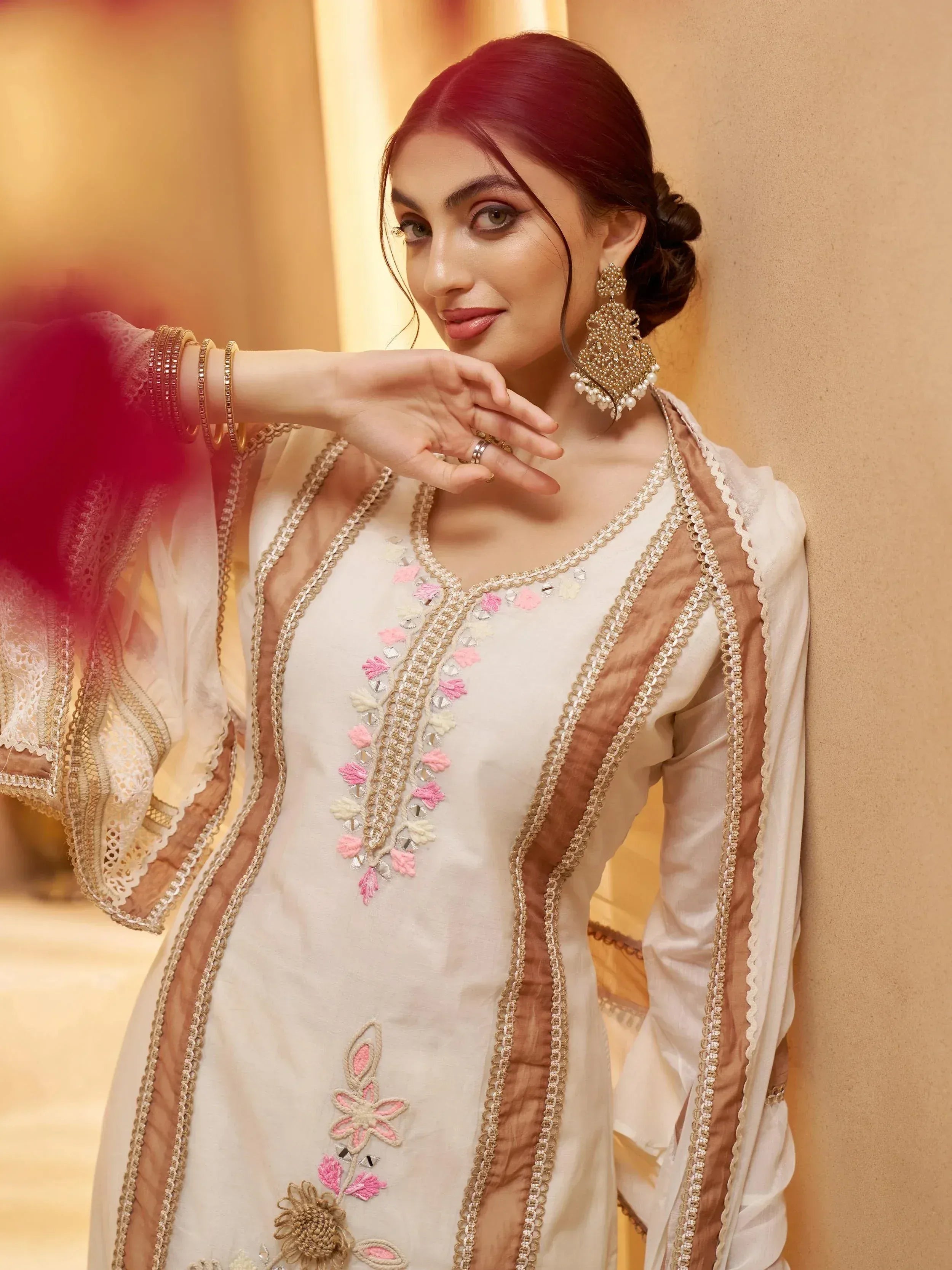 Elegant white salwar kameez with pink floral embroidery and gold detailing, perfect for Indian ethnic wear.