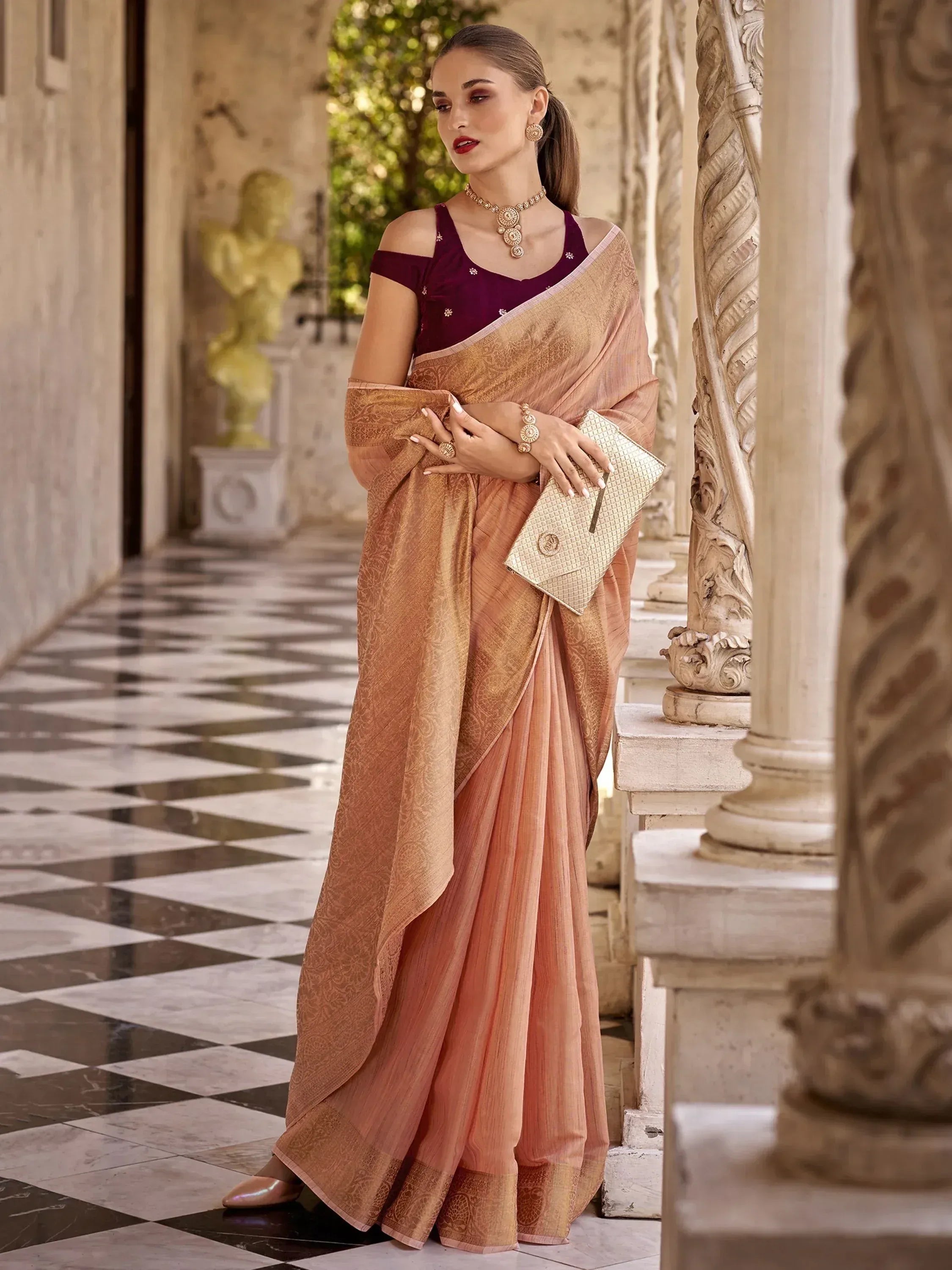 Elegant peach saree with gold embroidery, paired with maroon blouse, perfect for Indian ethnic occasions.