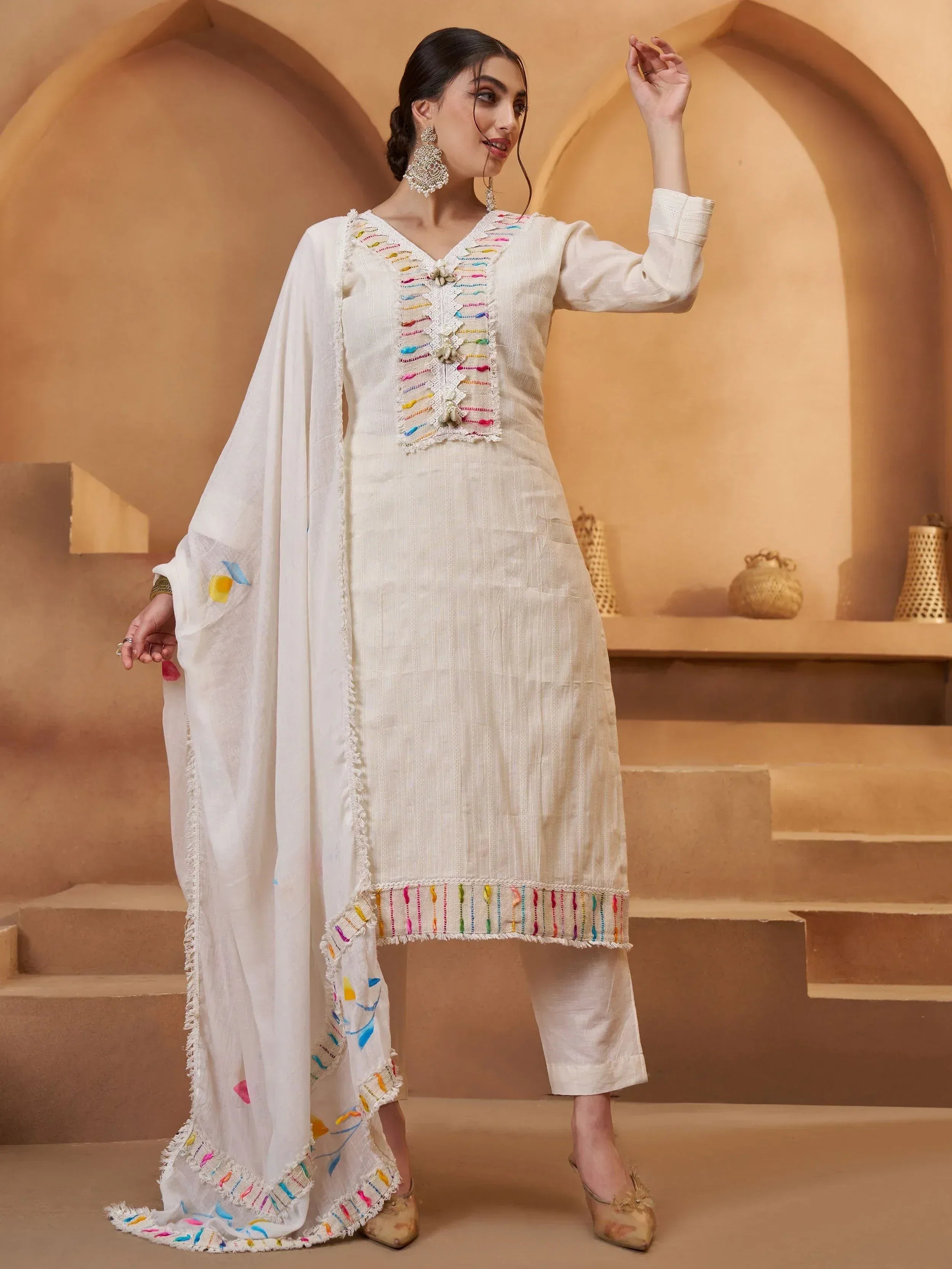 White ethnic salwar kameez with colorful thread embroidery and matching dupatta, perfect for festive occasions
