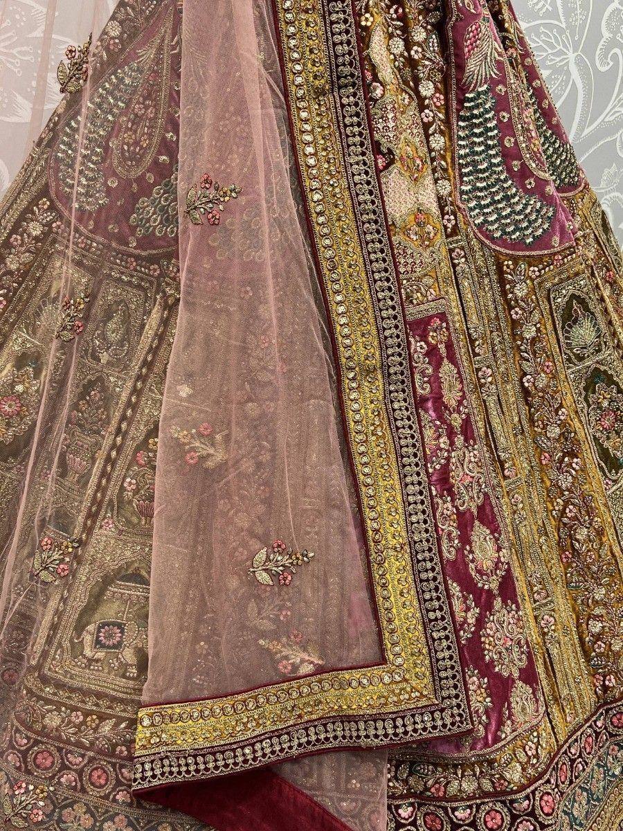 Luxury maroon lehenga choli with intricate gold embroidery and floral motifs, perfect for Indian weddings.