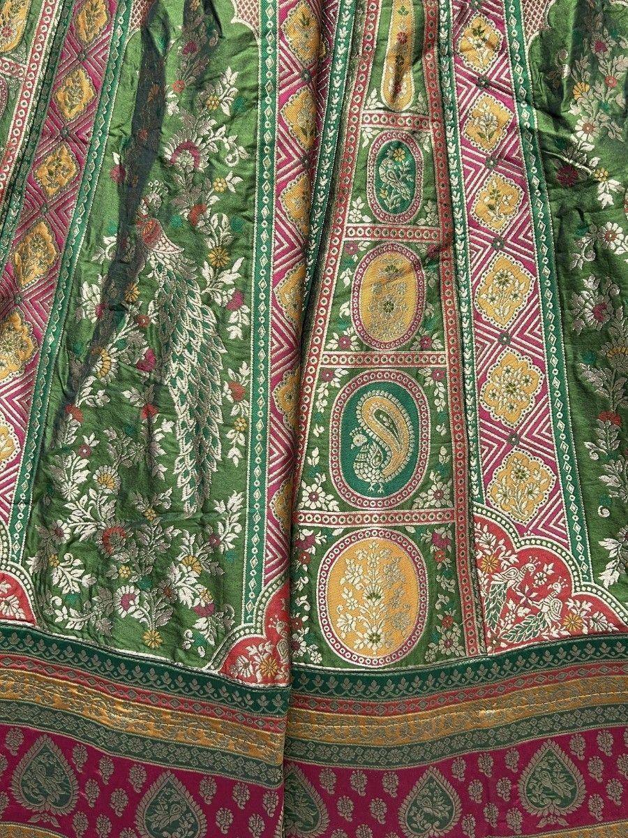 Green and pink ethnic lehenga with intricate paisley and floral embroidery, perfect for Indian weddings and festivals.