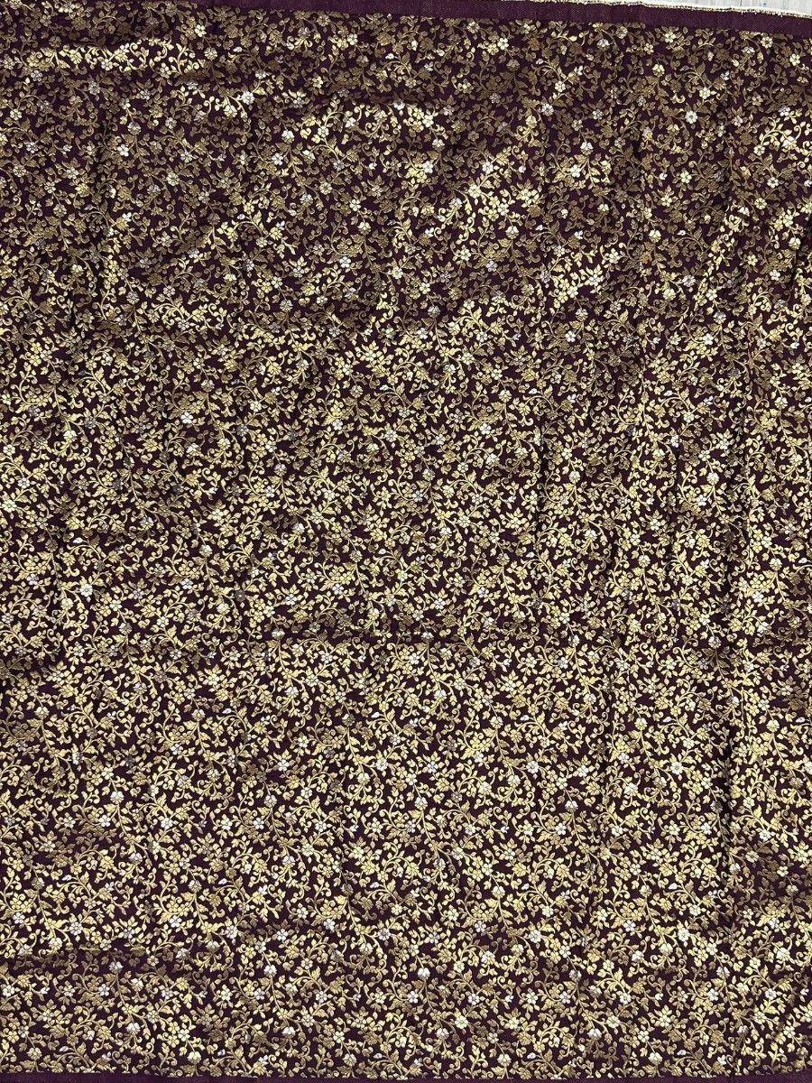 Dark purple fabric with intricate gold floral embroidery, ideal for ethnic wear like lehenga or saree