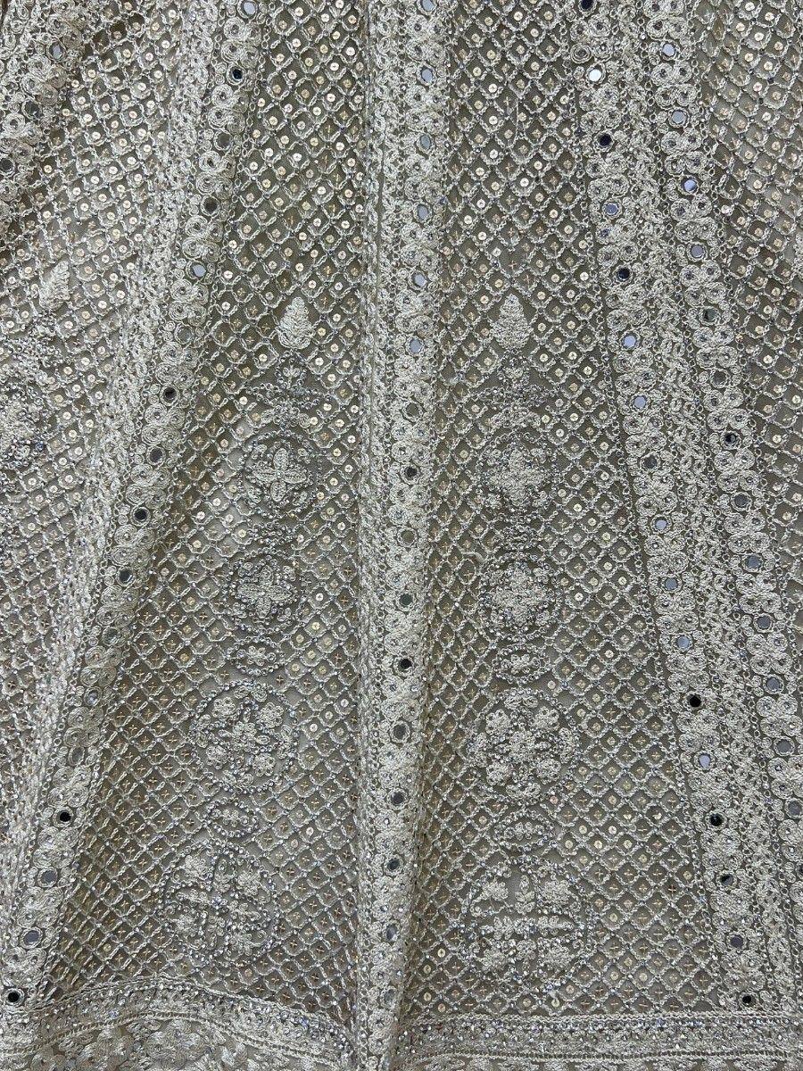 Silver ethnic gown with intricate mirror work and embroidery, perfect for Indian festive occasions.