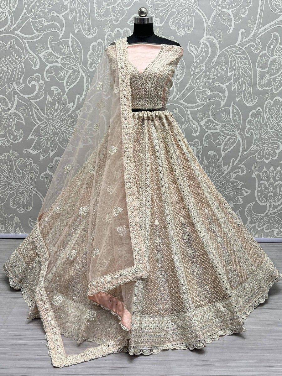 Elegant beige lehenga choli with intricate embroidery and net dupatta, perfect for Indian weddings and festive occasions.