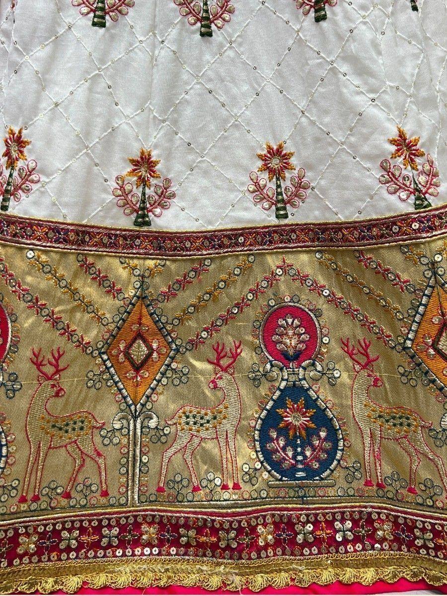 White and gold ethnic lehenga with deer embroidery, mirror work, and floral motifs for Indian weddings