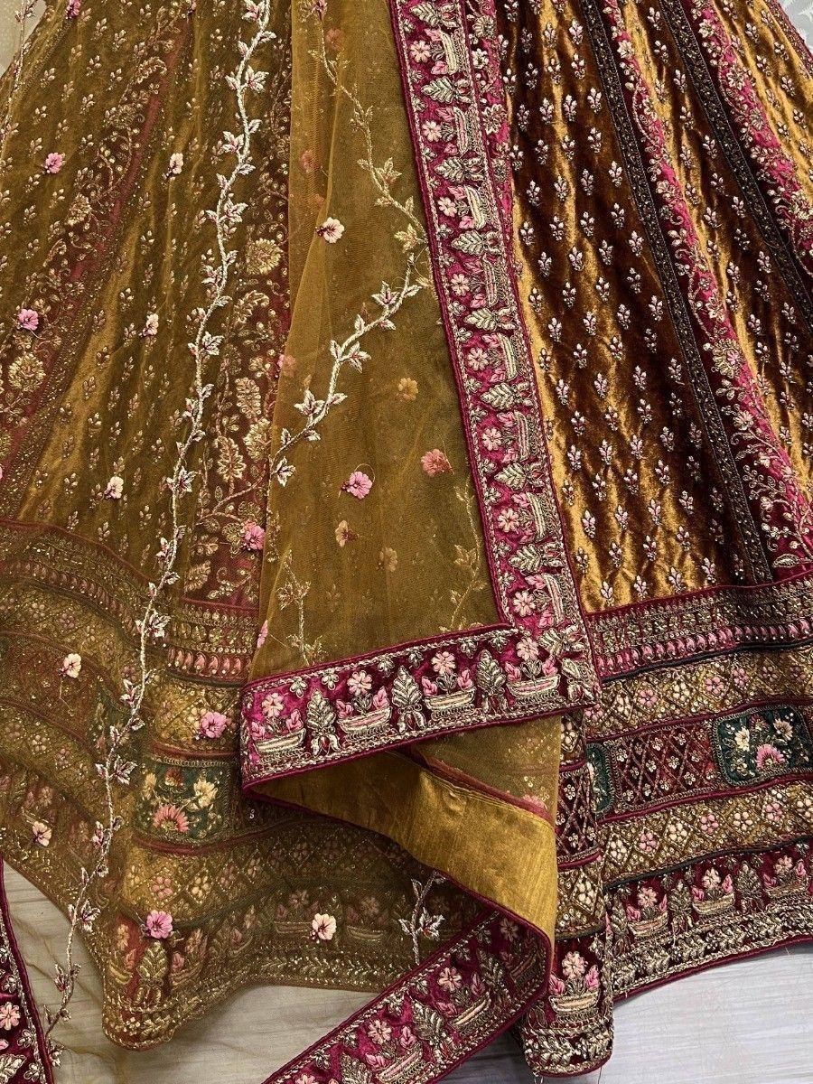Luxury gold velvet lehenga with pink floral embroidery and intricate border detailing for Indian ethnic wear