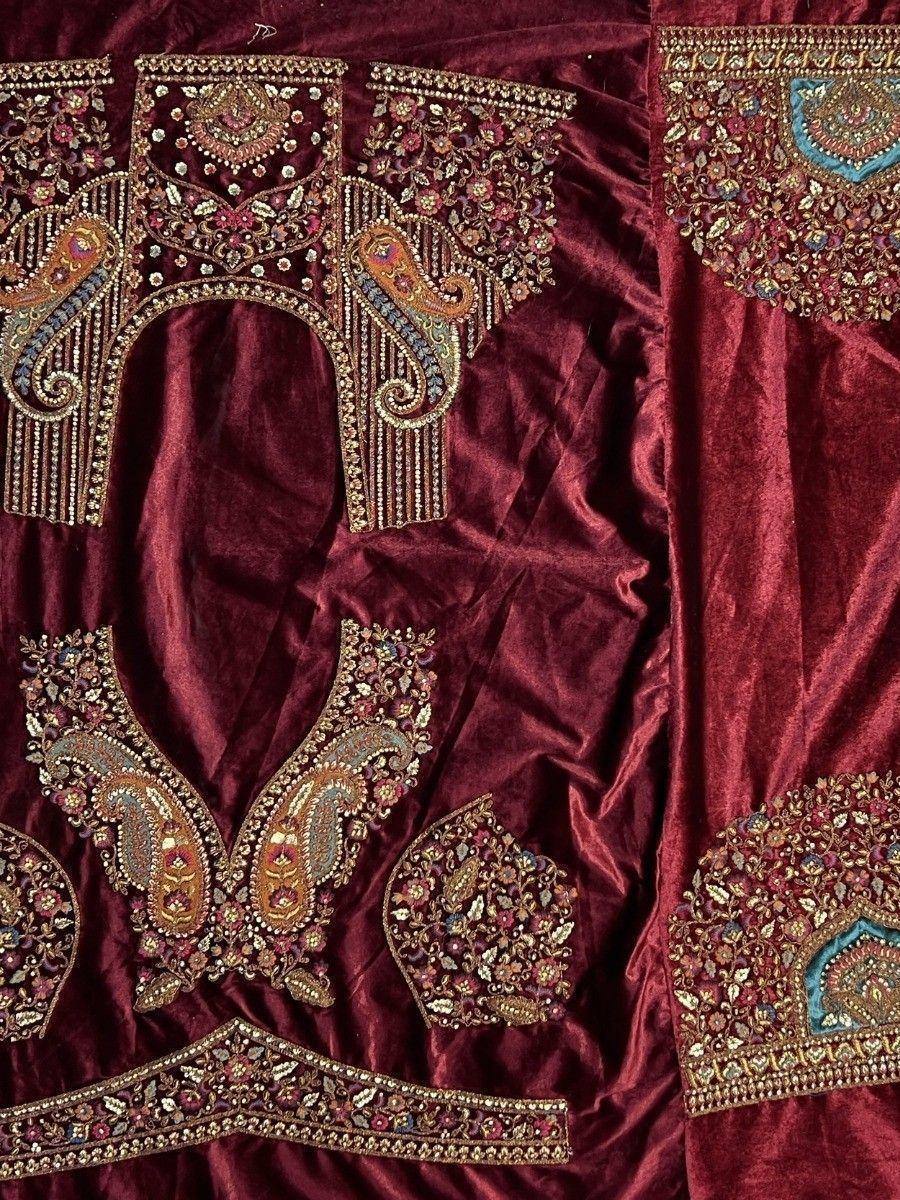Rich maroon velvet lehenga choli with intricate gold and multicolor embroidery, perfect for Indian ethnic wear.