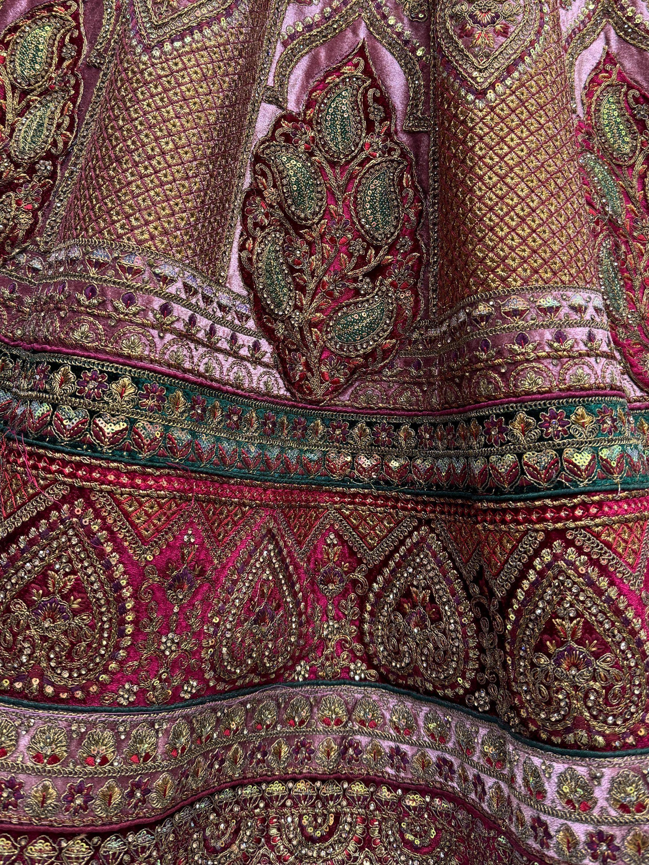 Luxury Indian ethnic wear with intricate gold embroidery, sequins, and paisley motifs on rich velvet fabric.