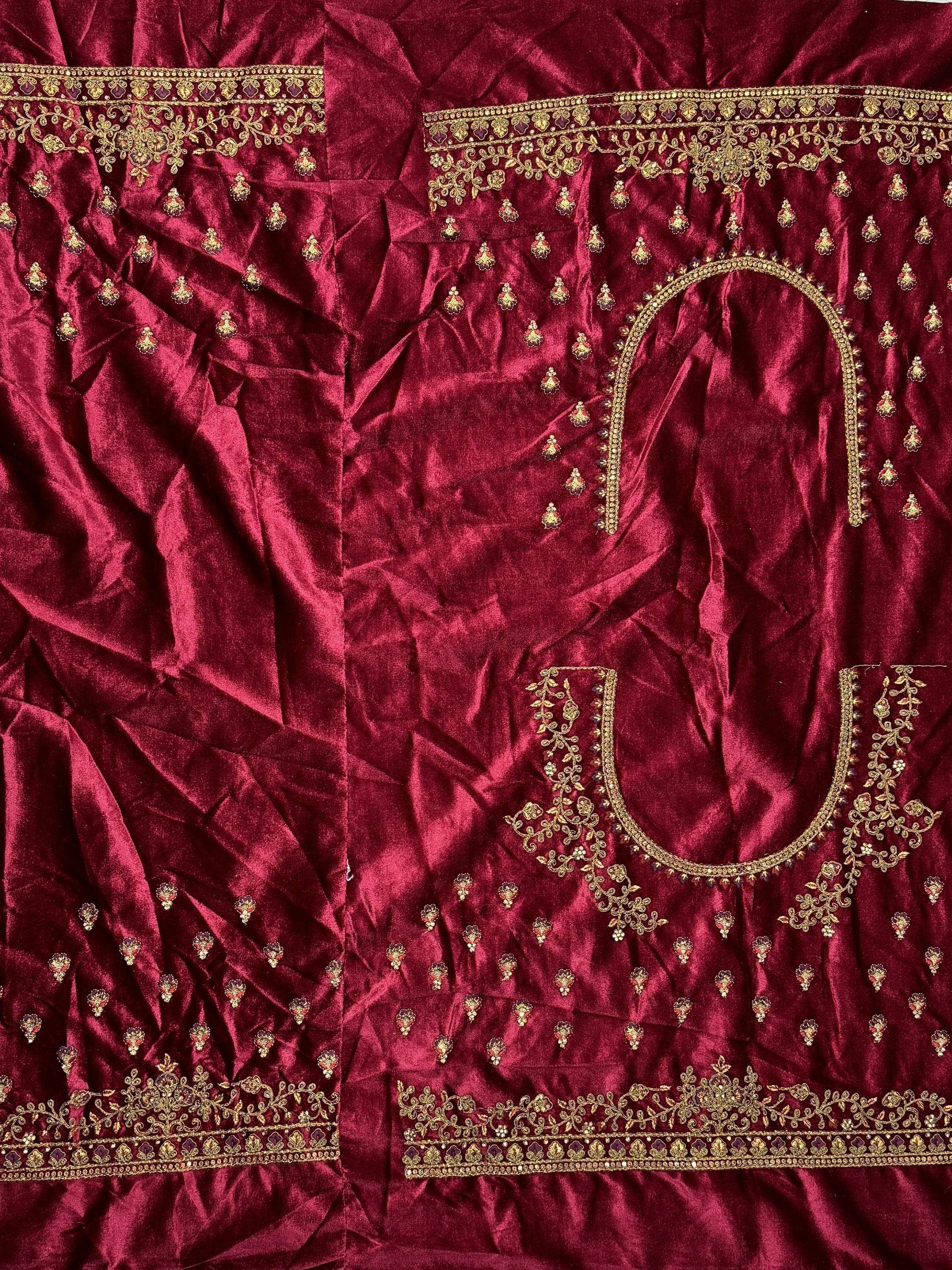 Rich maroon velvet ethnic wear with gold embroidery and embellishments, perfect for festive occasions.