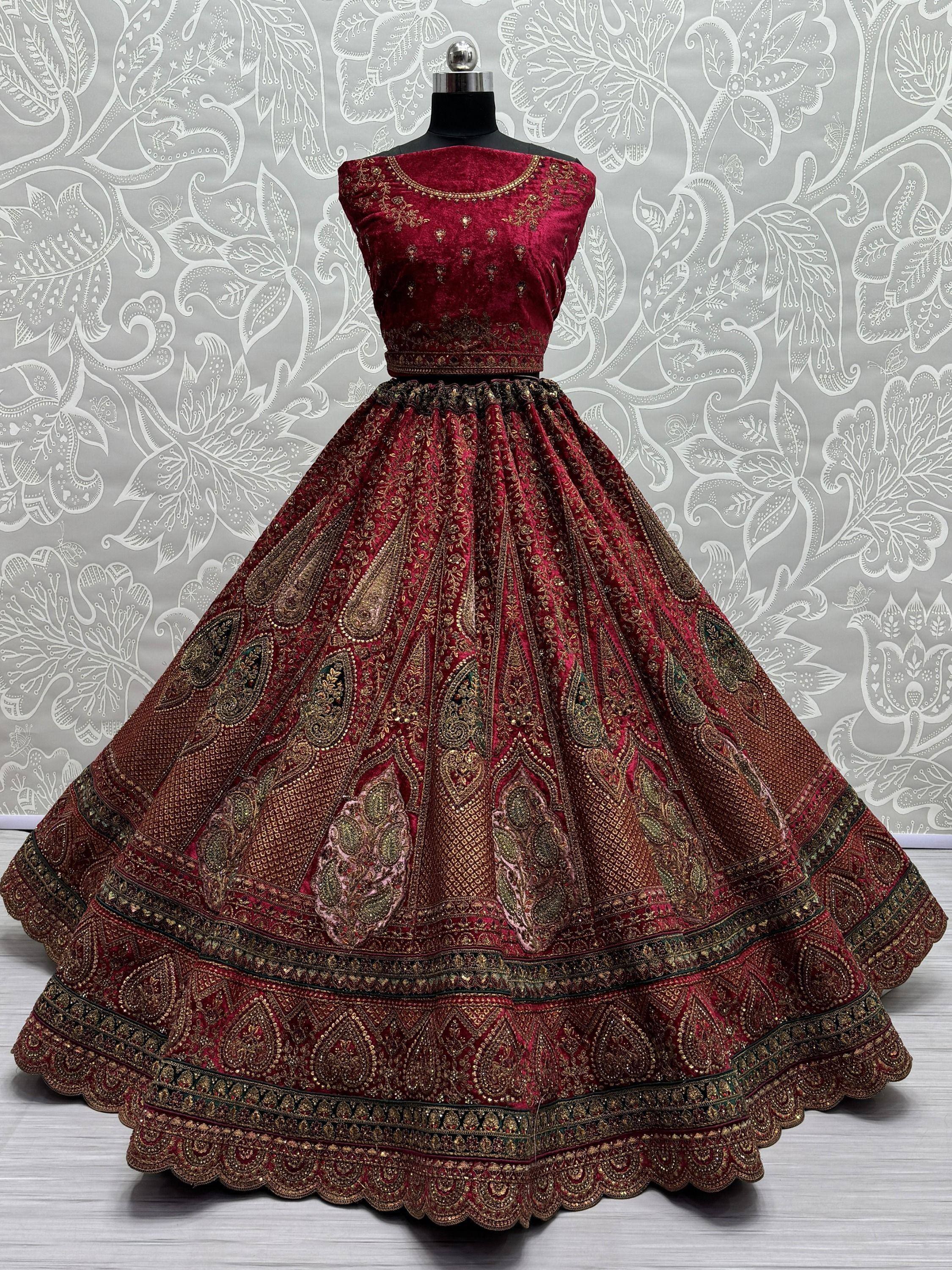 Maroon velvet designer lehenga choli with gold embroidery, perfect for Indian weddings and festive occasions.