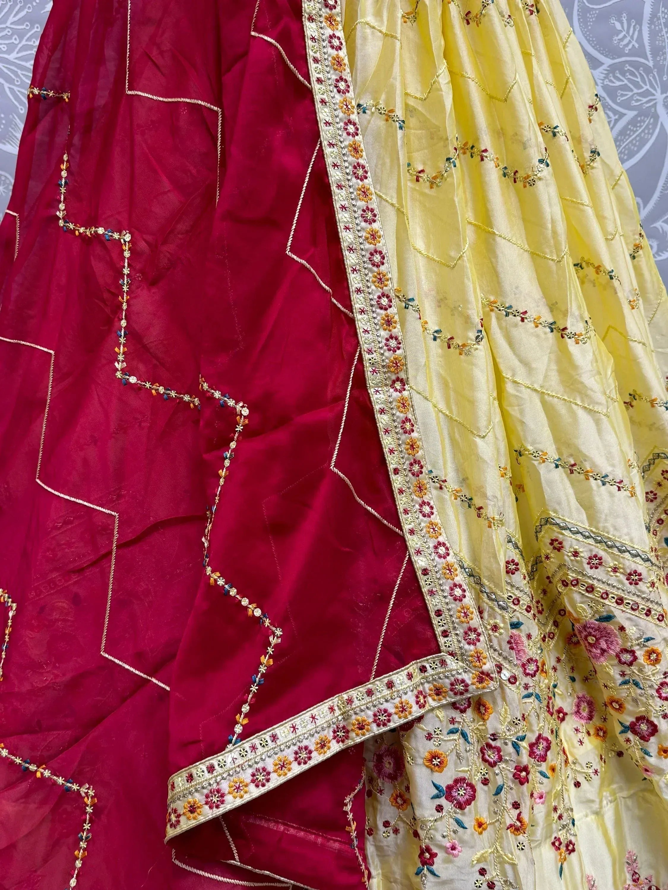 Red and yellow embroidered Indian ethnic wear with floral threadwork and border detailing