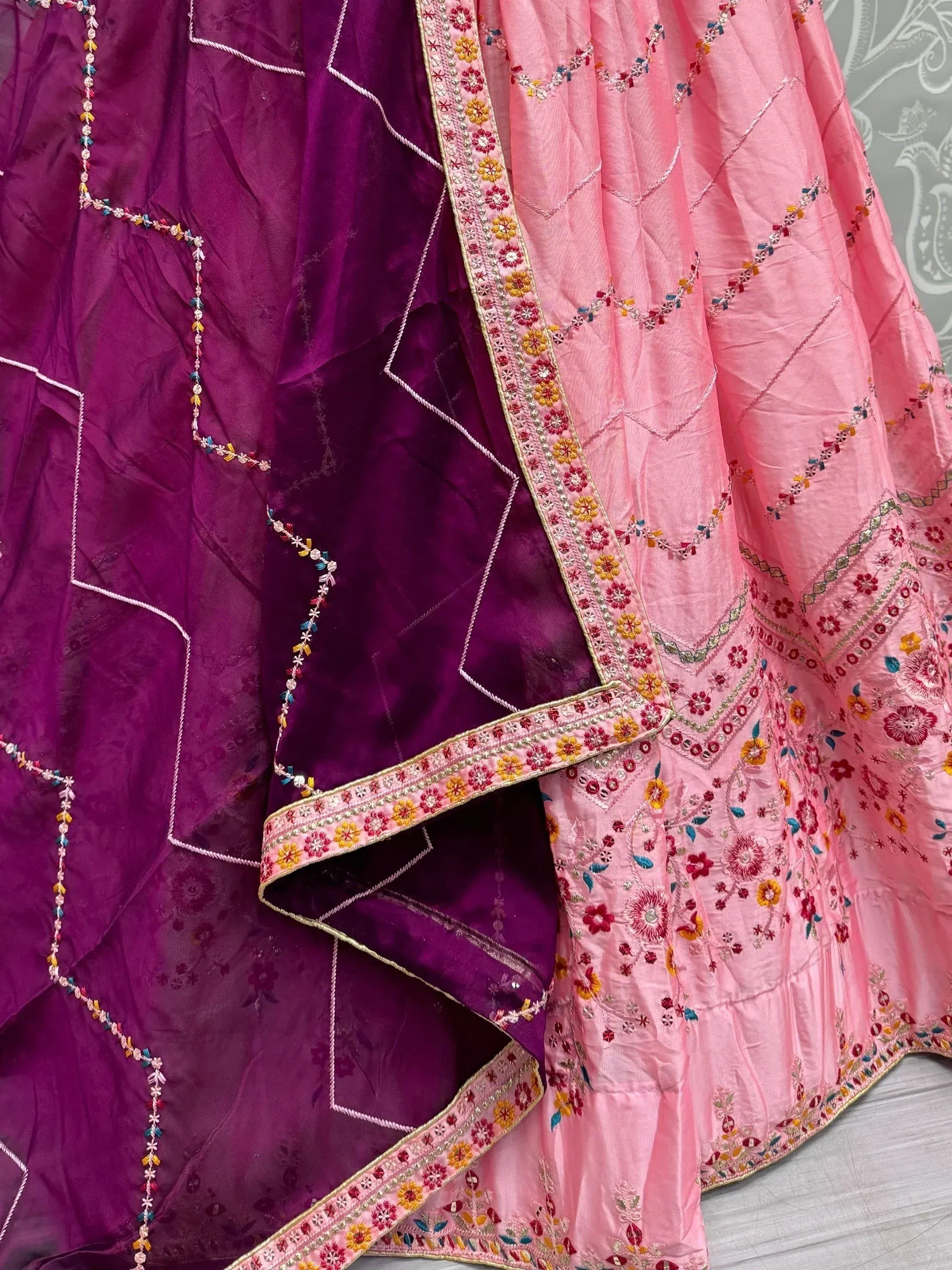 Pink and purple embroidered lehenga choli with floral mirror work and geometric patterns
