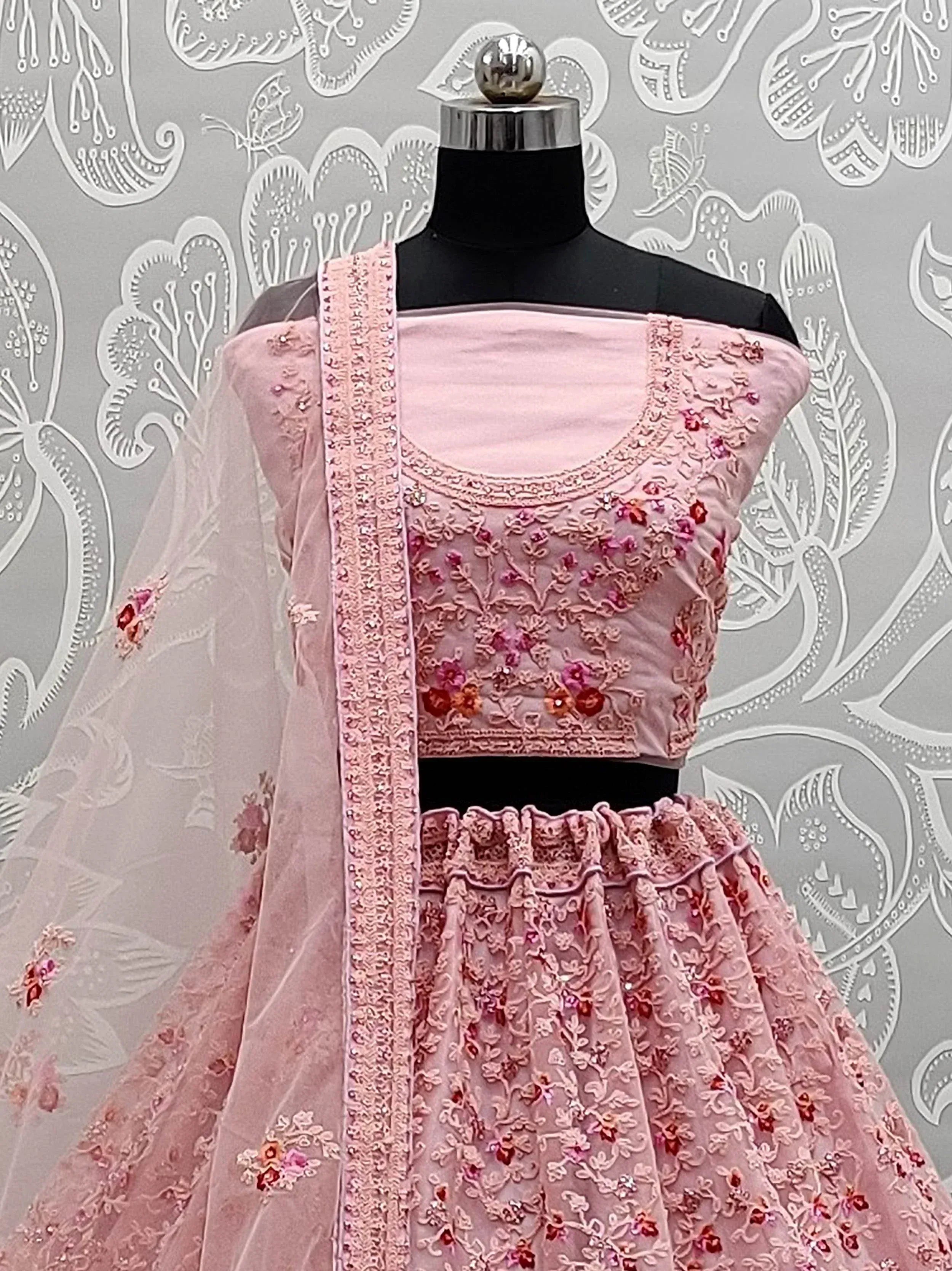 Pink embroidered lehenga choli with floral motifs and sheer dupatta, perfect for Indian ethnic wear occasions.