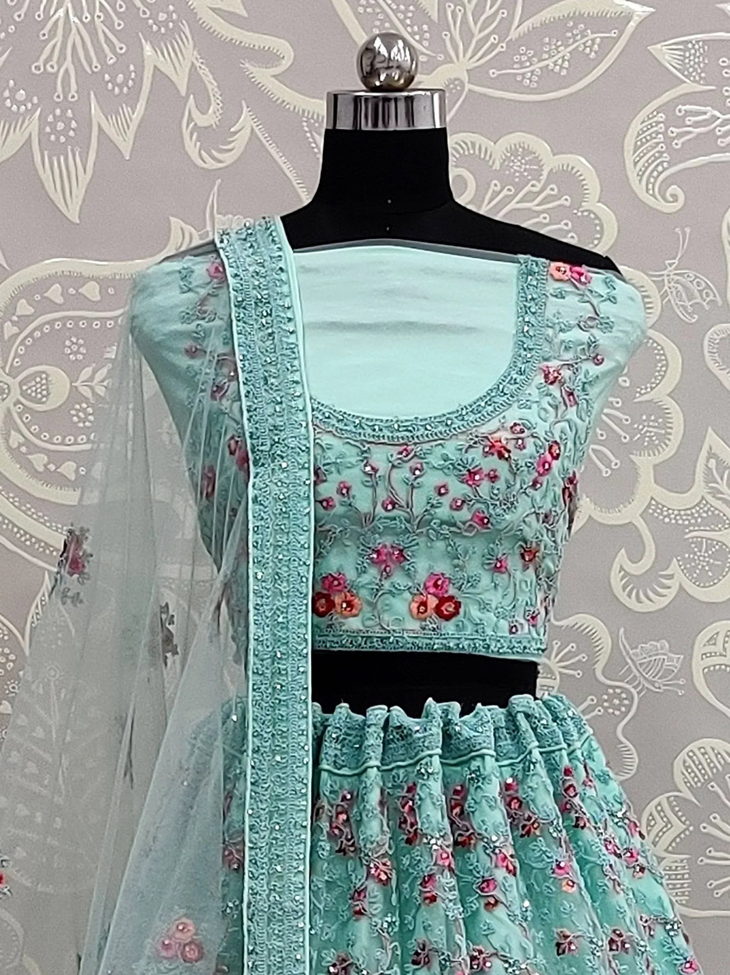 Mint green embroidered lehenga choli with floral motifs and sheer dupatta, displayed on mannequin