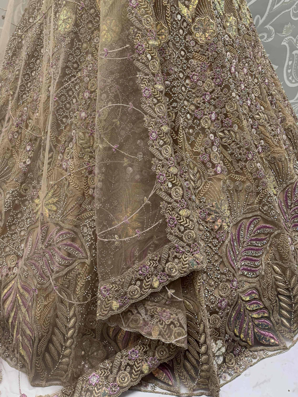 Elegant gold and purple embroidered lehenga choli with intricate floral and leaf motifs, perfect for Indian ethnic wear.