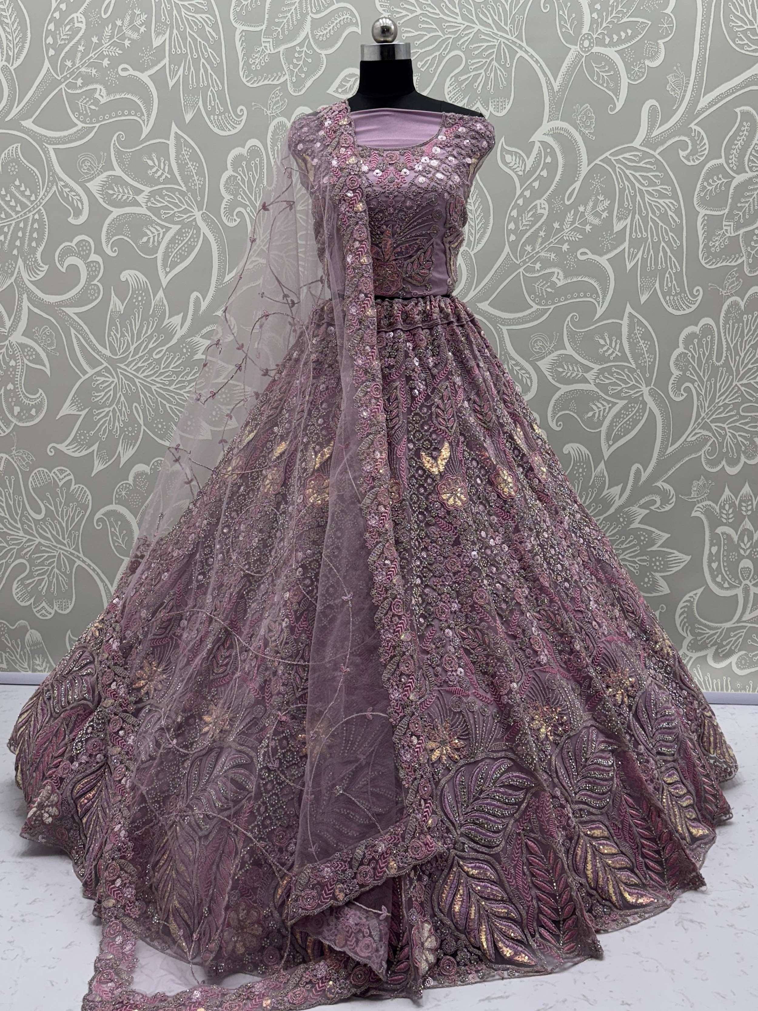 Elegant purple designer lehenga choli with heavy embroidery and sequins, perfect for Indian weddings and festive occasions.