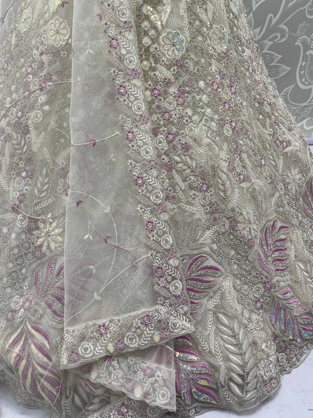 Elegant ethnic gown with floral embroidery, sequins, and sheer overlay in soft pastel tones