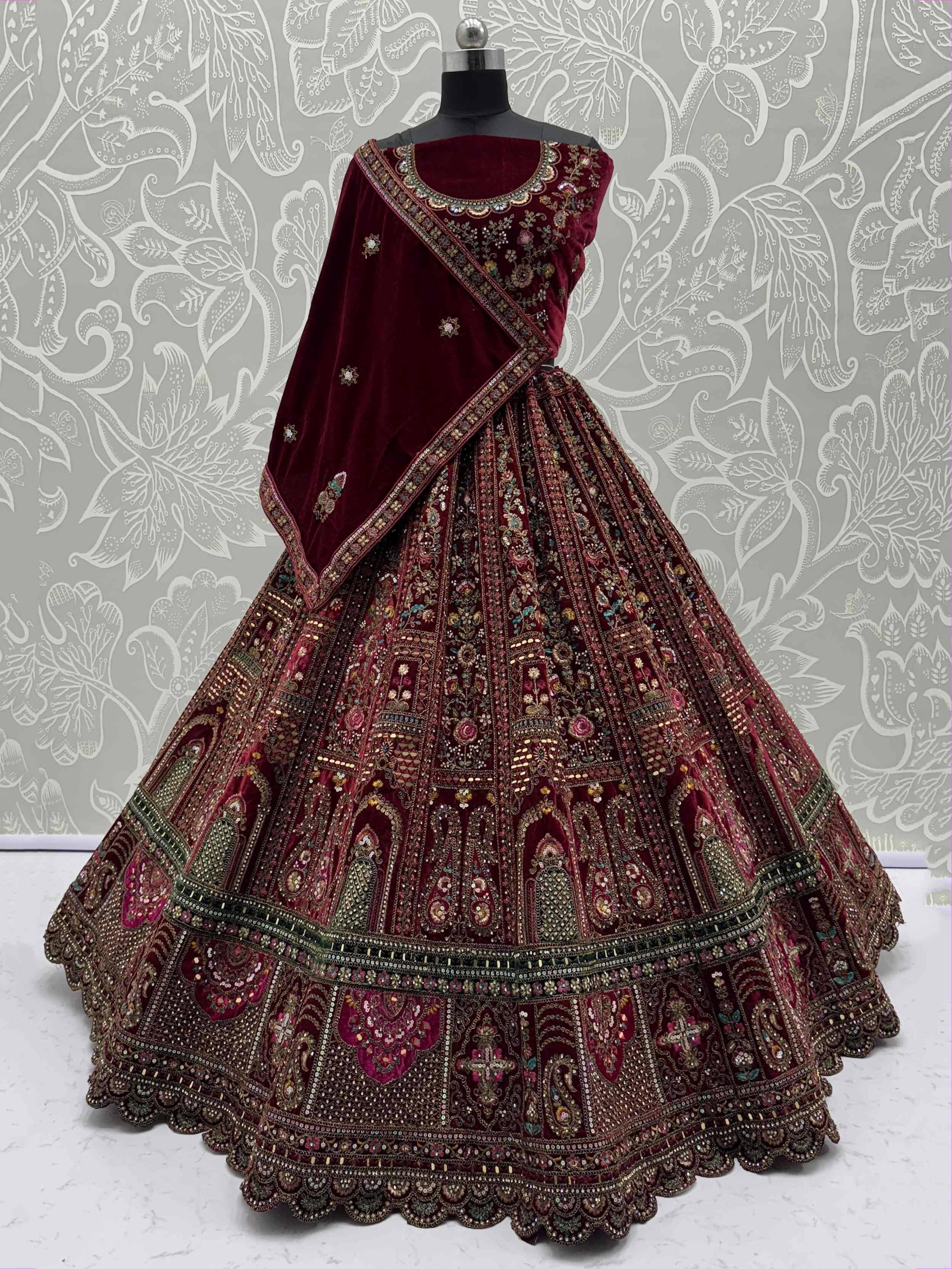 Maroon velvet lehenga choli with intricate embroidery and heavy embellishments, perfect for Indian weddings and festive occasions.
