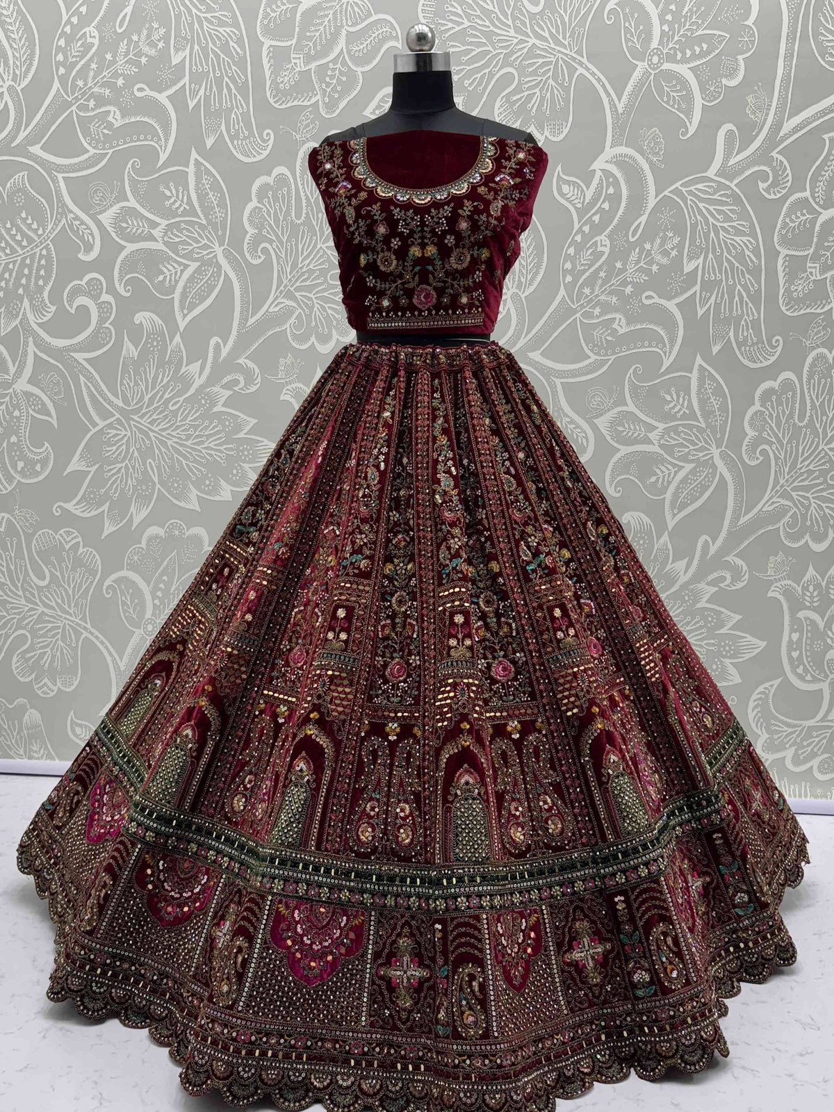 Maroon velvet lehenga choli with intricate floral embroidery and embellished skirt, perfect for Indian ethnic wear.