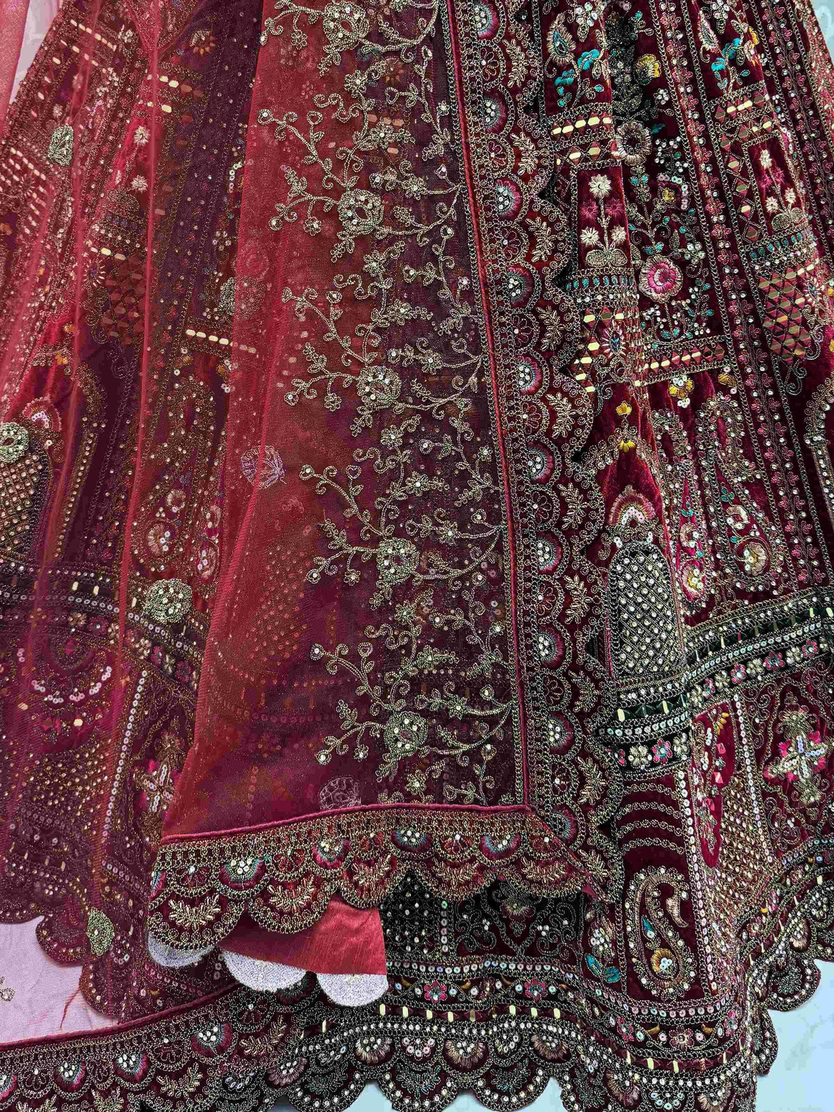 Richly embroidered maroon lehenga with intricate gold and colorful beadwork detailing