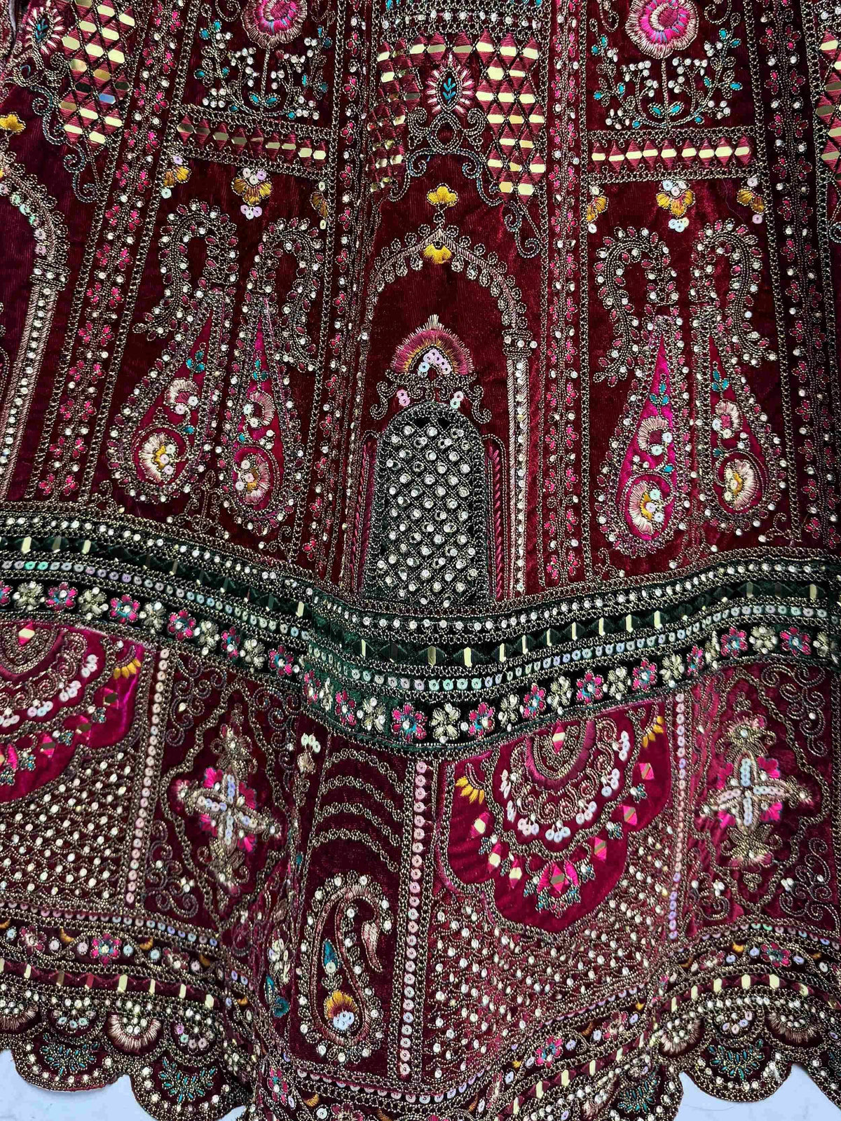 Richly embroidered maroon ethnic gown with intricate beadwork and mirror detailing