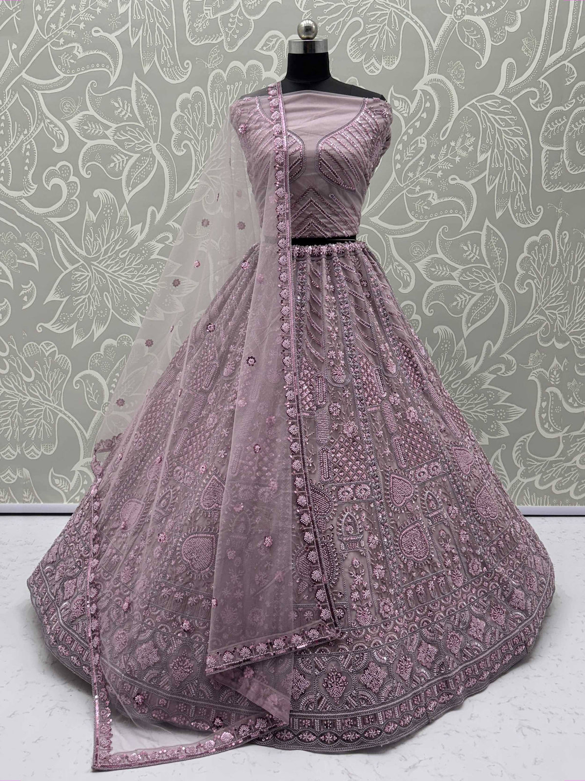 Dusty pink designer lehenga choli with intricate embroidery and sequin work, perfect for Indian ethnic wear.