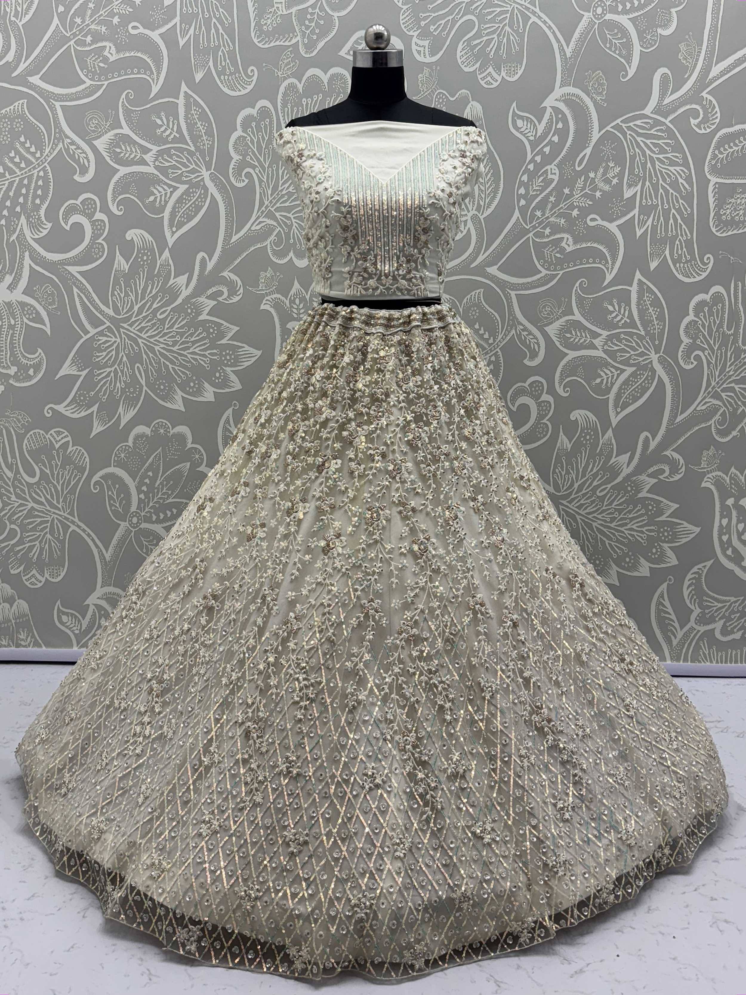 Elegant cream designer lehenga choli with intricate floral embroidery and sequins, perfect for Indian ethnic wear.