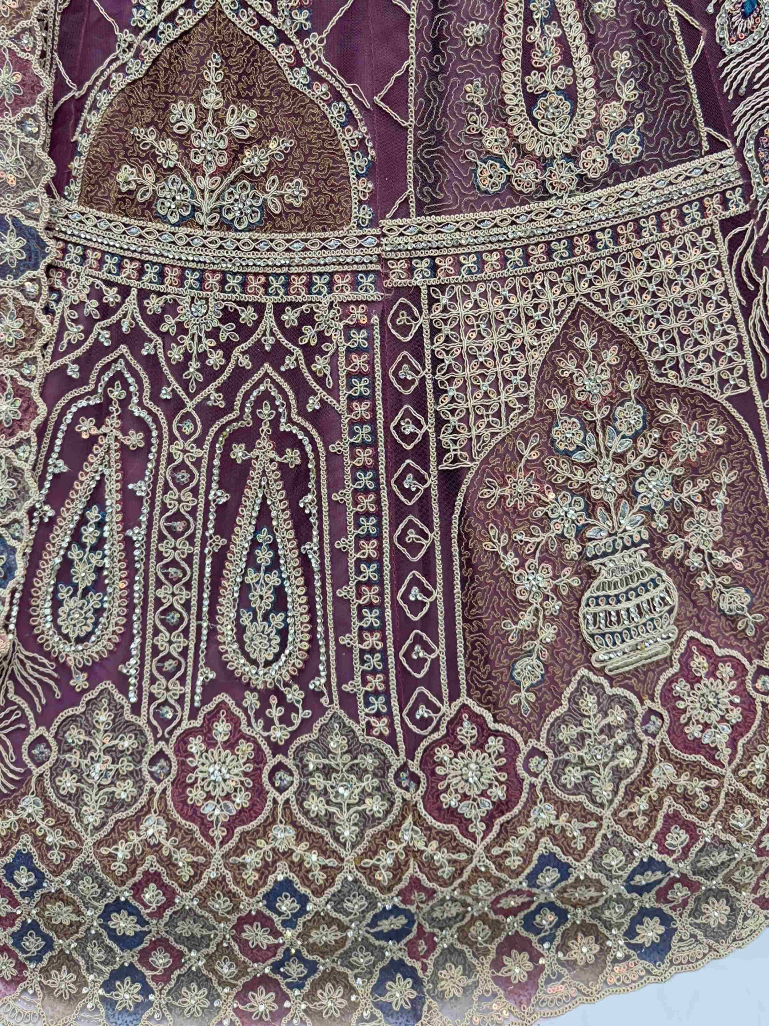 Richly embroidered maroon ethnic gown with gold threadwork, floral motifs, and sequin detailing for festive occasions