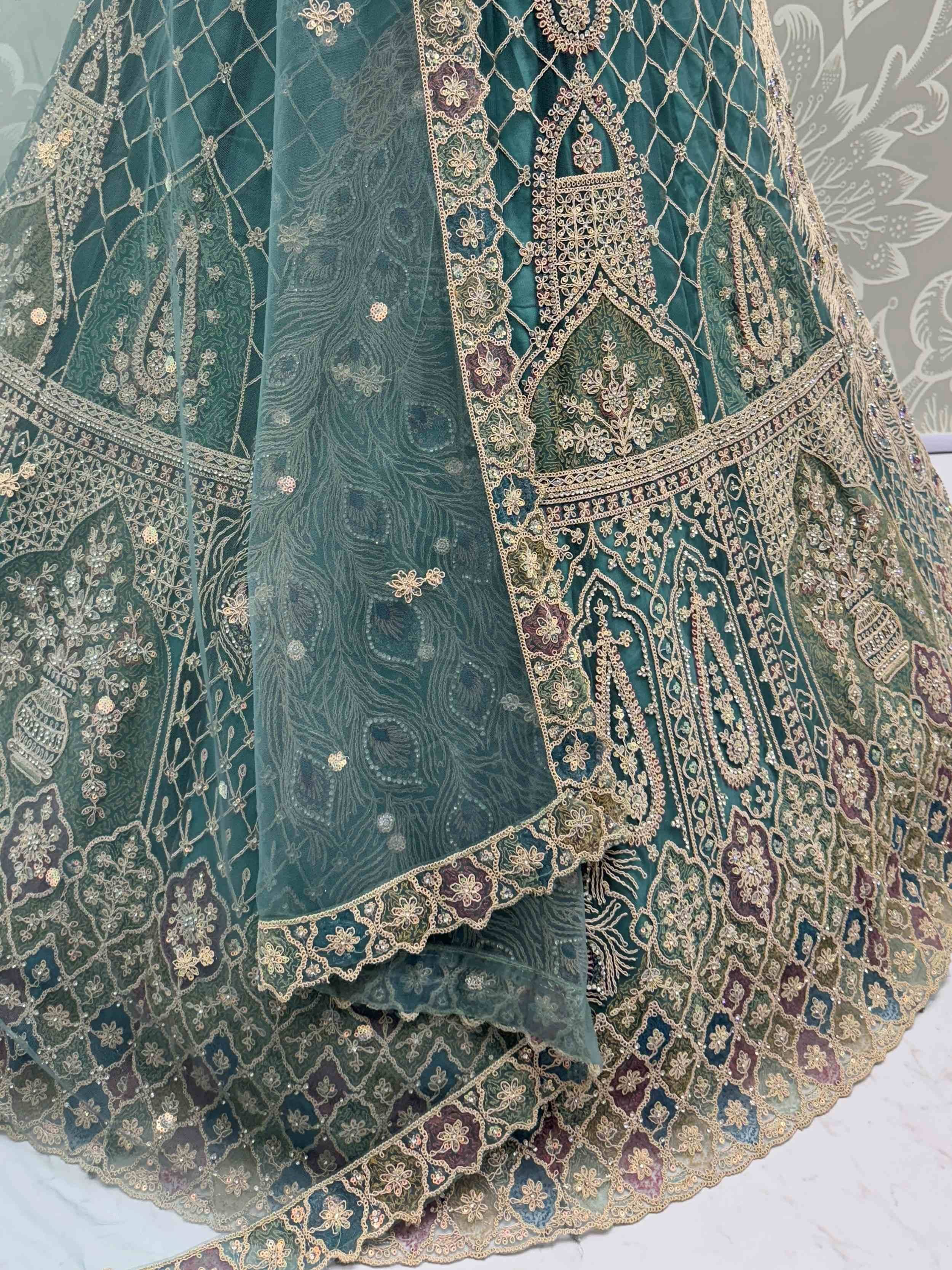 Emerald green designer lehenga with intricate gold embroidery and peacock motif dupatta