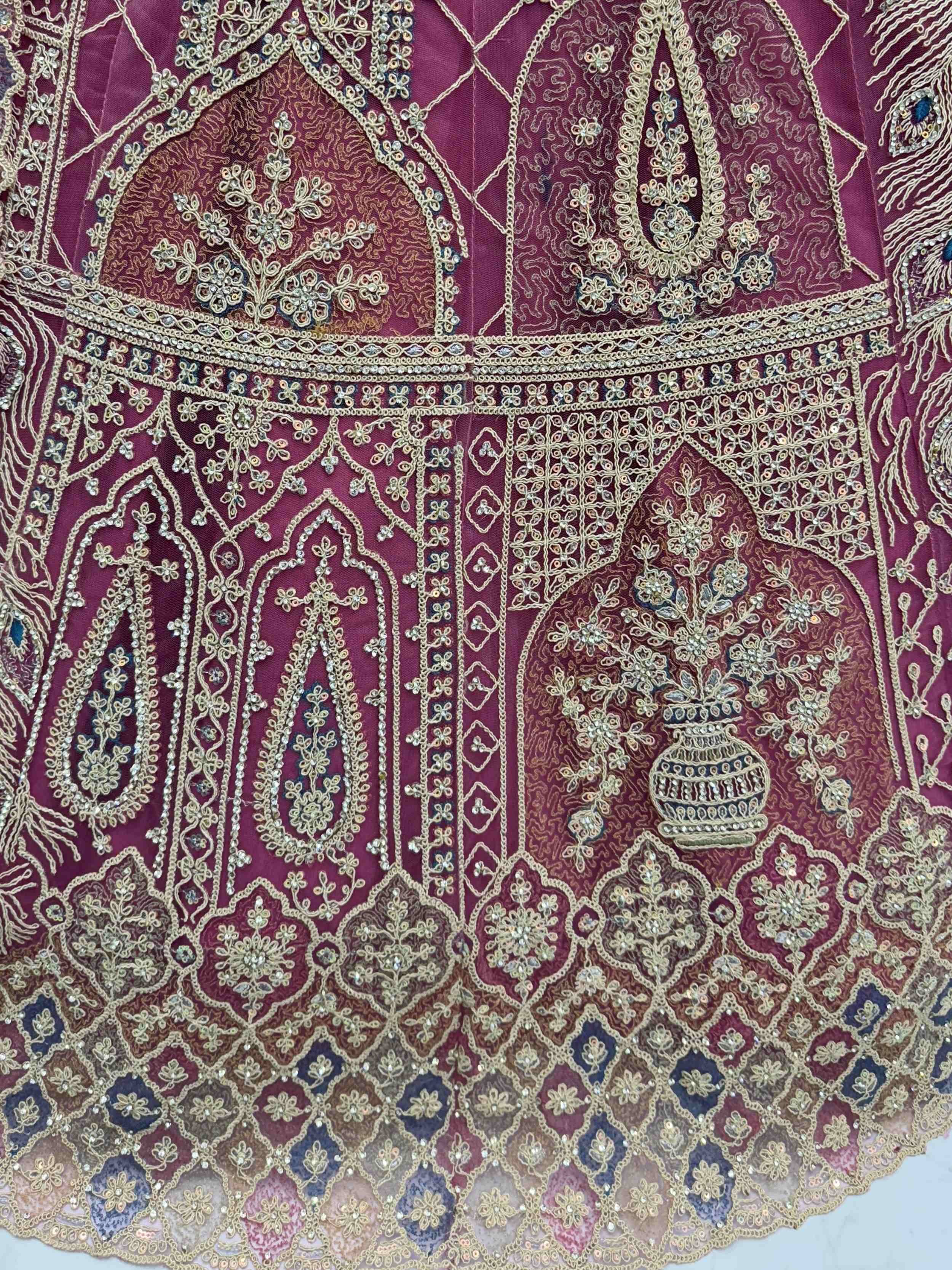 Luxury maroon lehenga with intricate gold embroidery and beadwork, perfect for Indian ethnic wear.