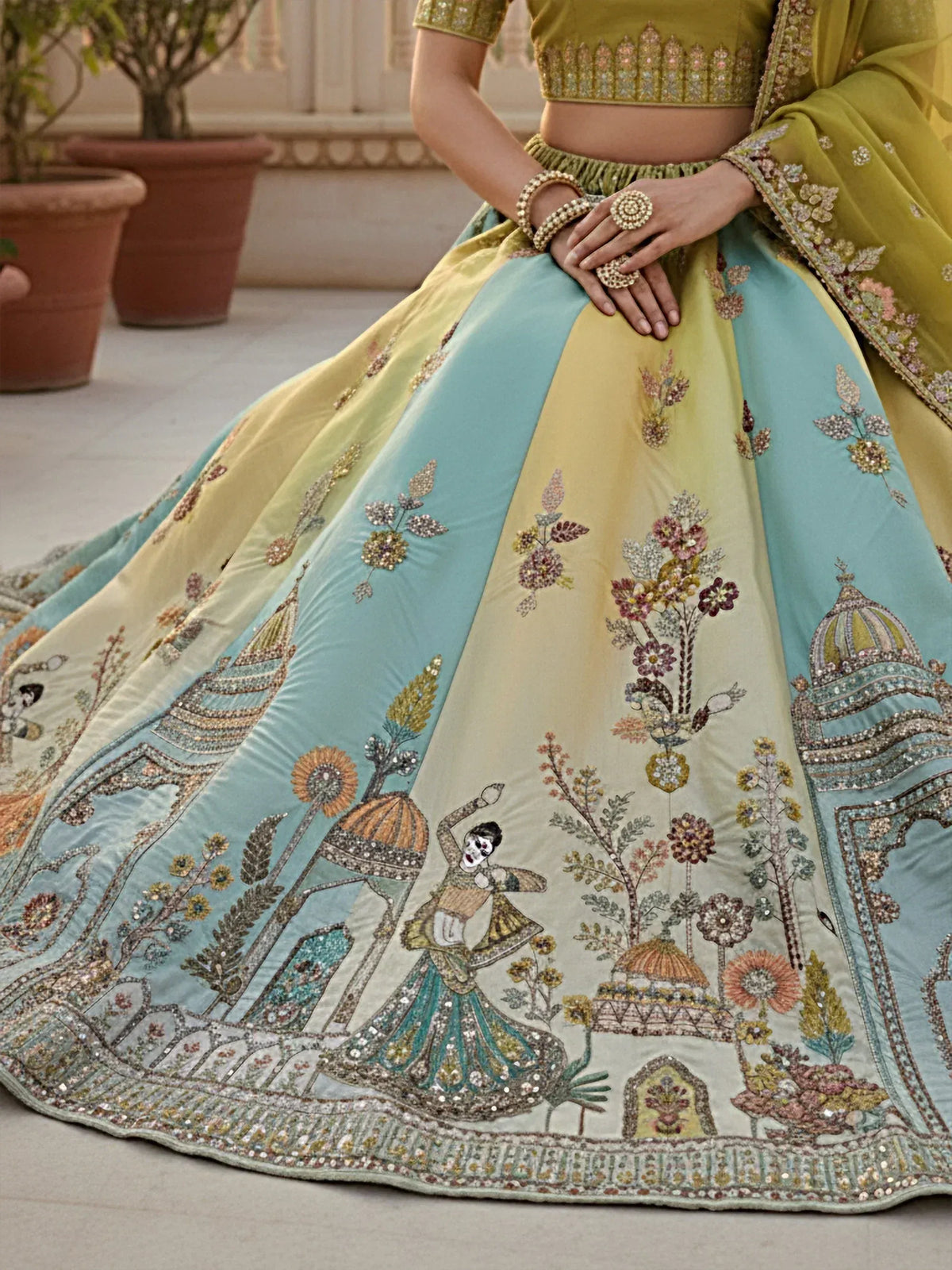 Elegant Indian lehenga choli with intricate floral and temple embroidery in pastel hues, perfect for weddings.