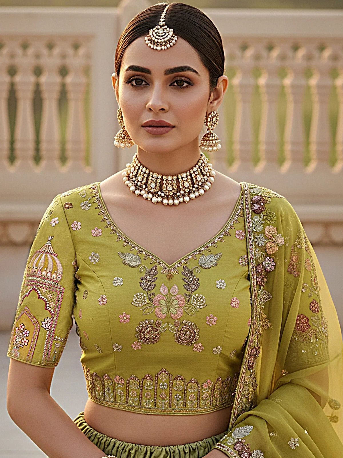 Olive green embroidered lehenga choli with floral motifs, heavy jewelry, and dupatta for Indian ethnic wear