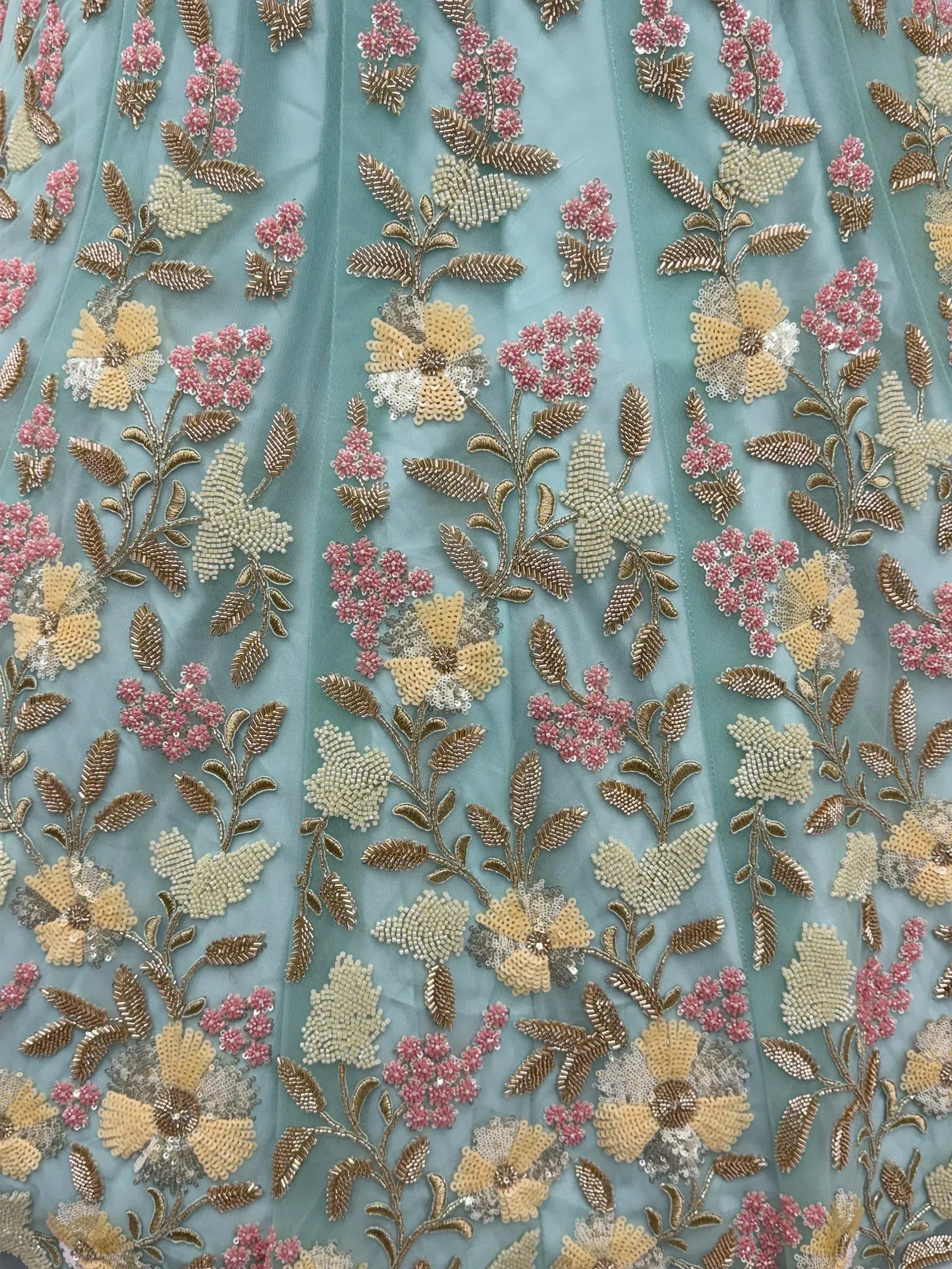 Elegant teal fabric with floral embroidery in gold, pink, and beige for ethnic wear