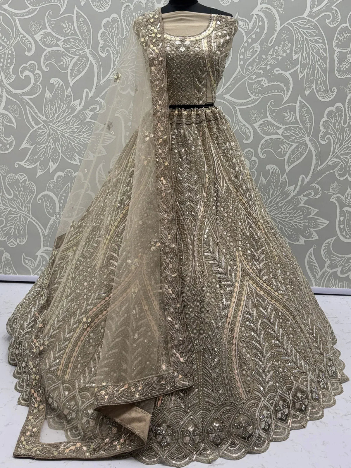 Elegant gold embroidered lehenga choli with sheer dupatta, perfect for Indian weddings and festive occasions.