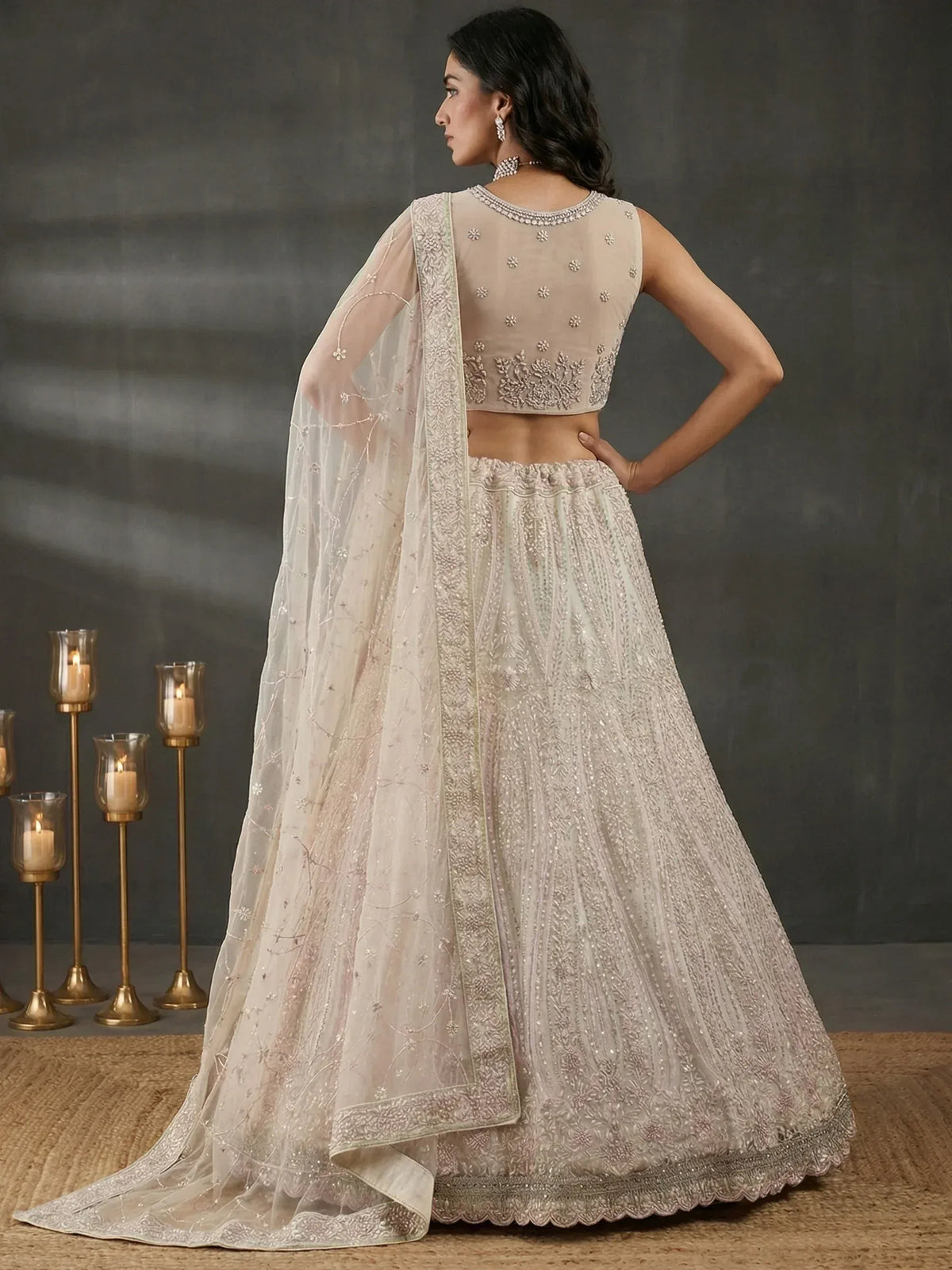 Elegant ivory lehenga choli with intricate embroidery and sheer dupatta, perfect for Indian weddings and festive occasions.