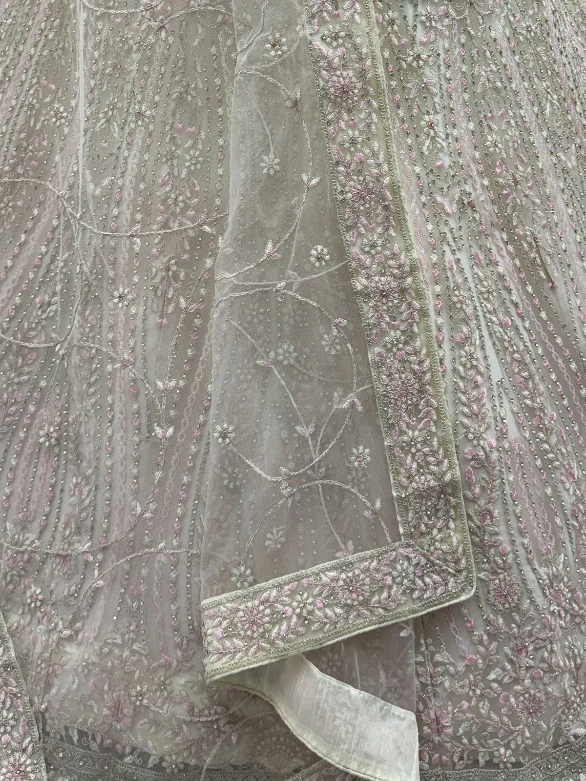 Delicate floral embroidery on sheer grey Indian ethnic wear with pink and silver threadwork details.