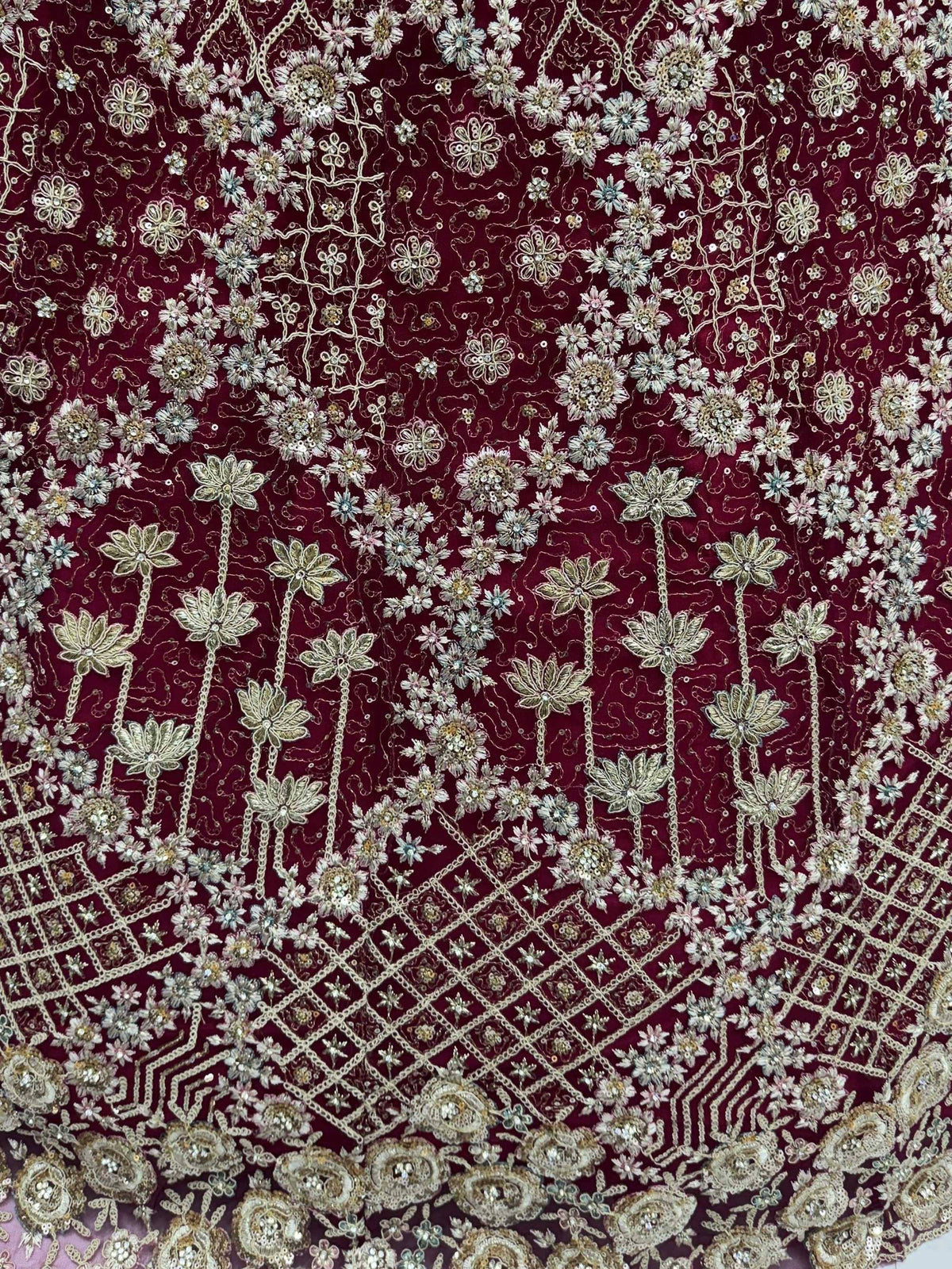 Rich maroon ethnic fabric with intricate floral embroidery and sequin detailing for designer lehenga choli