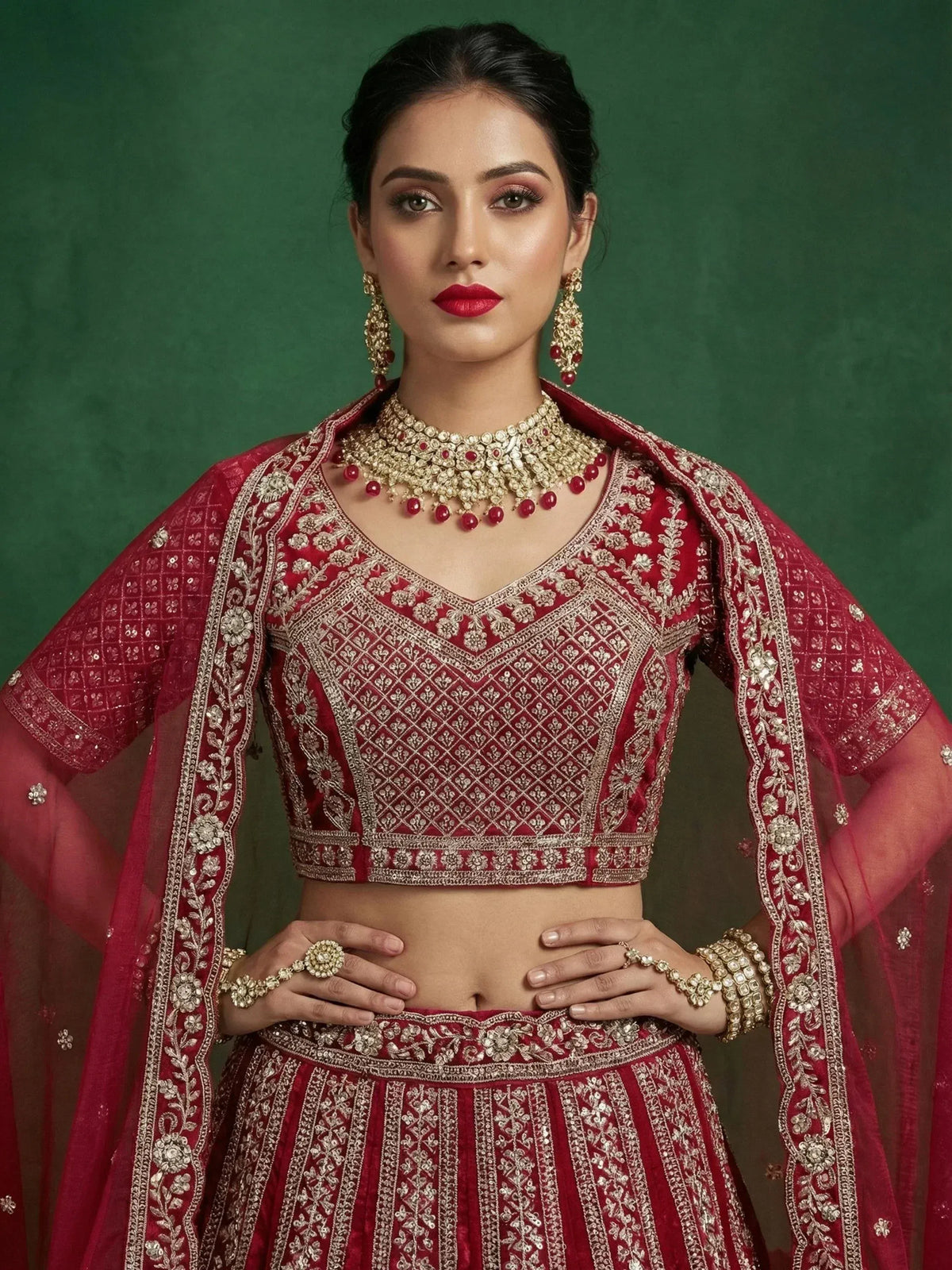 Elegant maroon lehenga choli with intricate gold embroidery and matching jewelry for Indian ethnic wear.