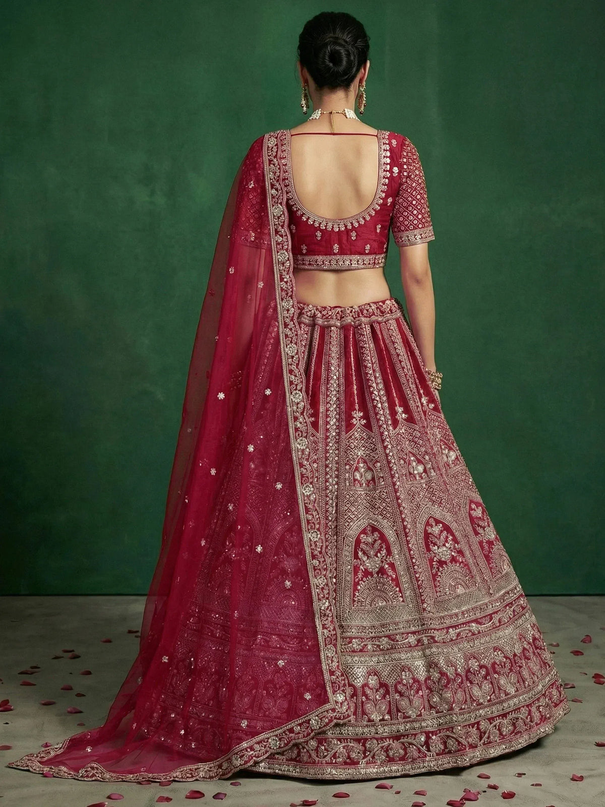 Elegant maroon lehenga choli with intricate gold embroidery and sheer dupatta, perfect for Indian weddings.