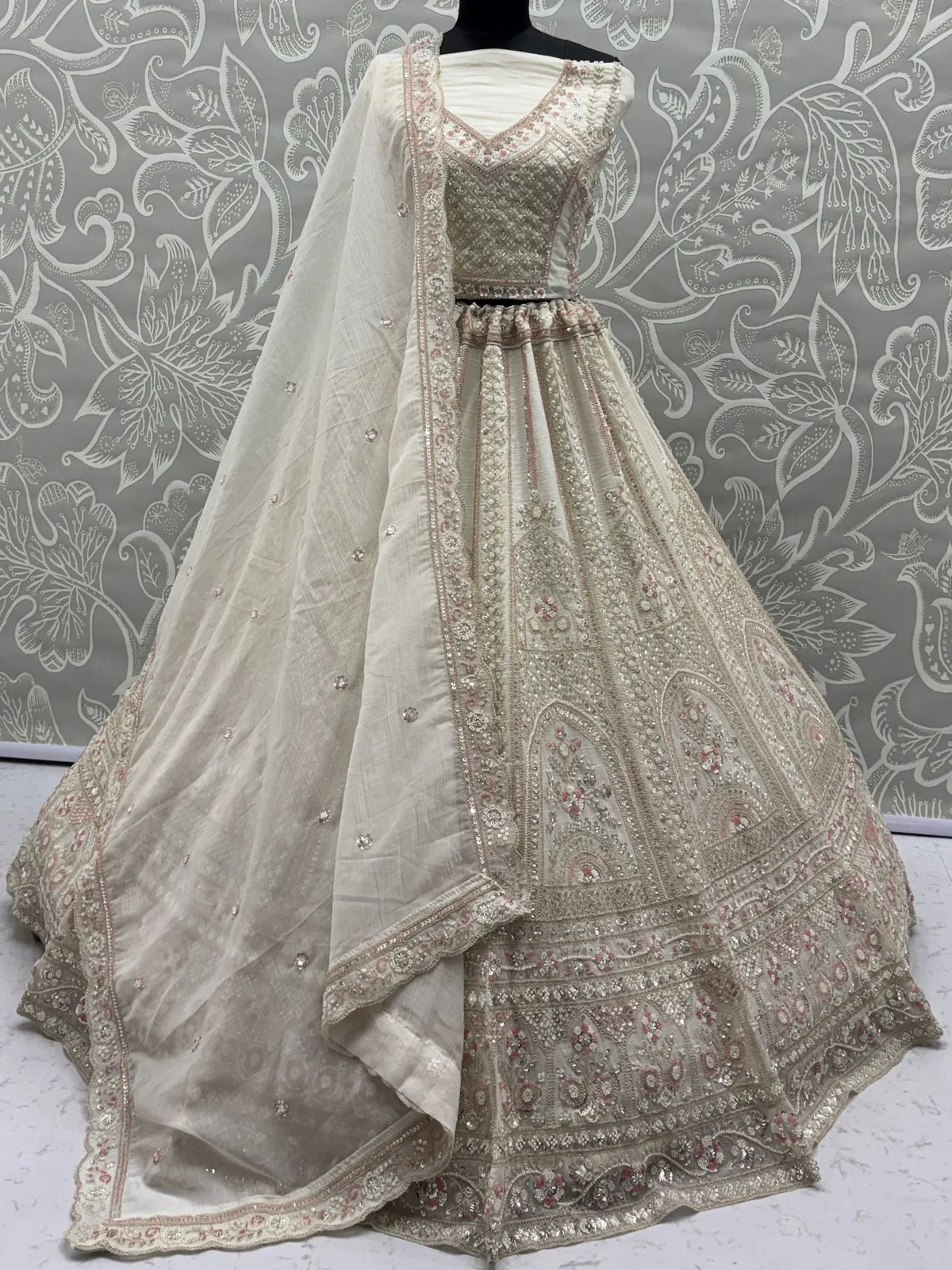 Elegant off-white lehenga choli with intricate embroidery and floral patterns, perfect for Indian ethnic wear.