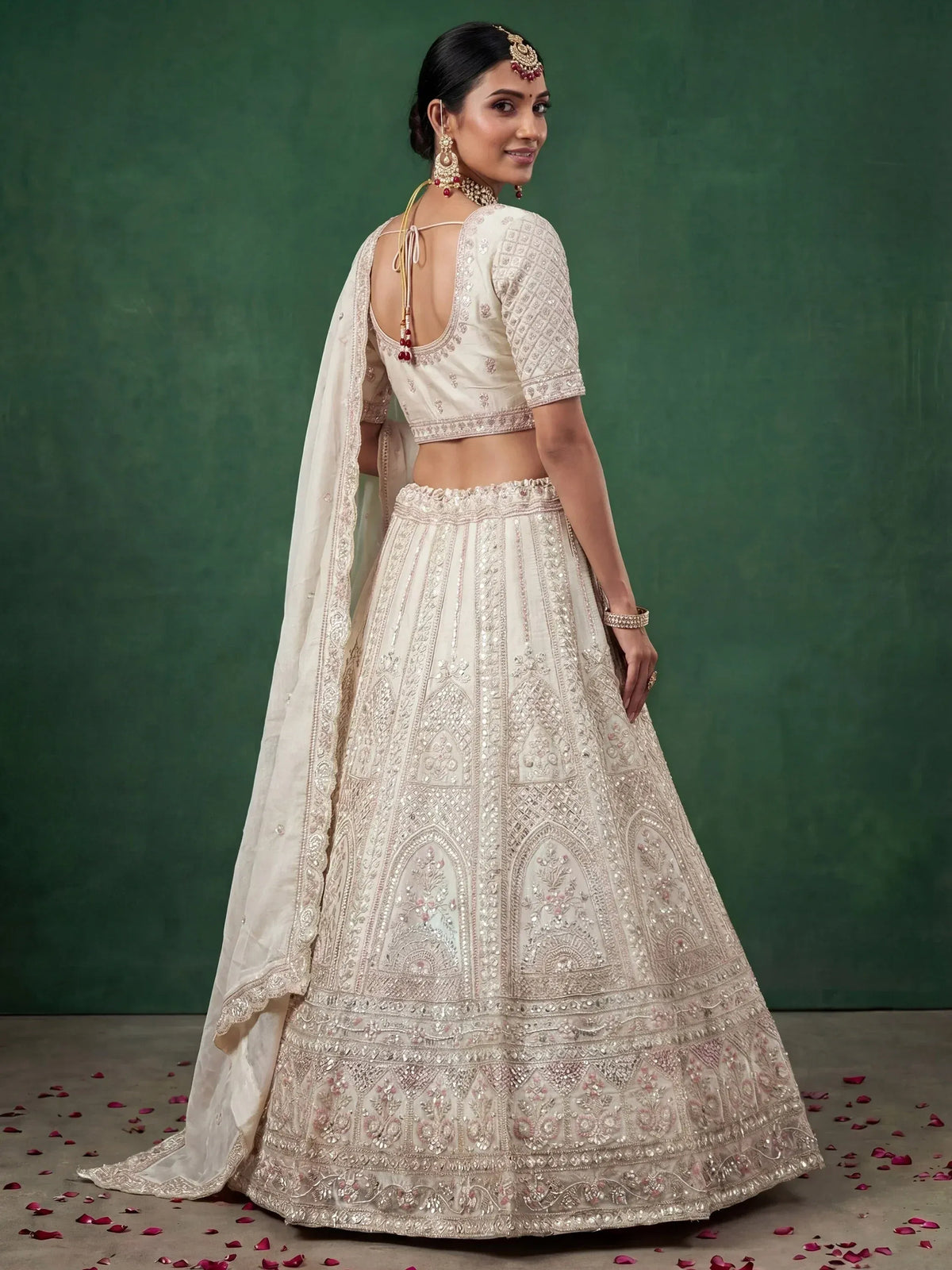 Elegant cream lehenga choli with intricate embroidery and floral details, perfect for Indian weddings.