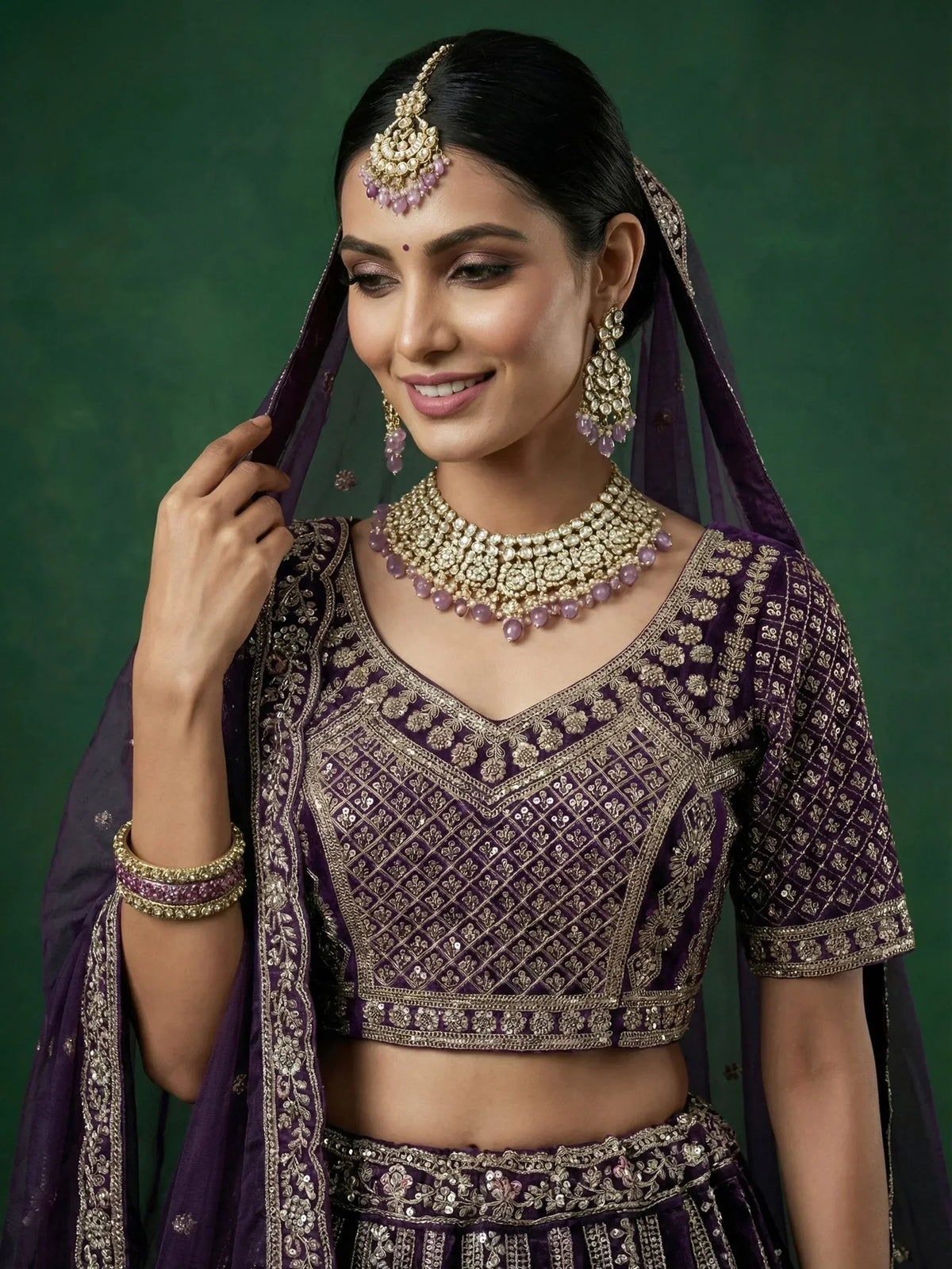 Elegant purple lehenga choli with gold embroidery and matching jewelry for Indian ethnic wear